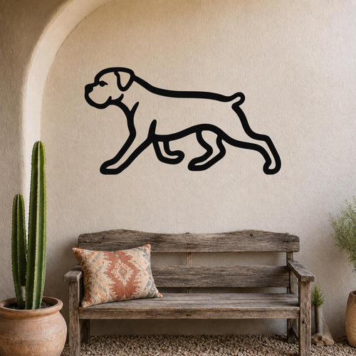 Black metal Boxer dog silhouette wall art mounted on a stucco wall above a wooden bench in a rustic patio setting.