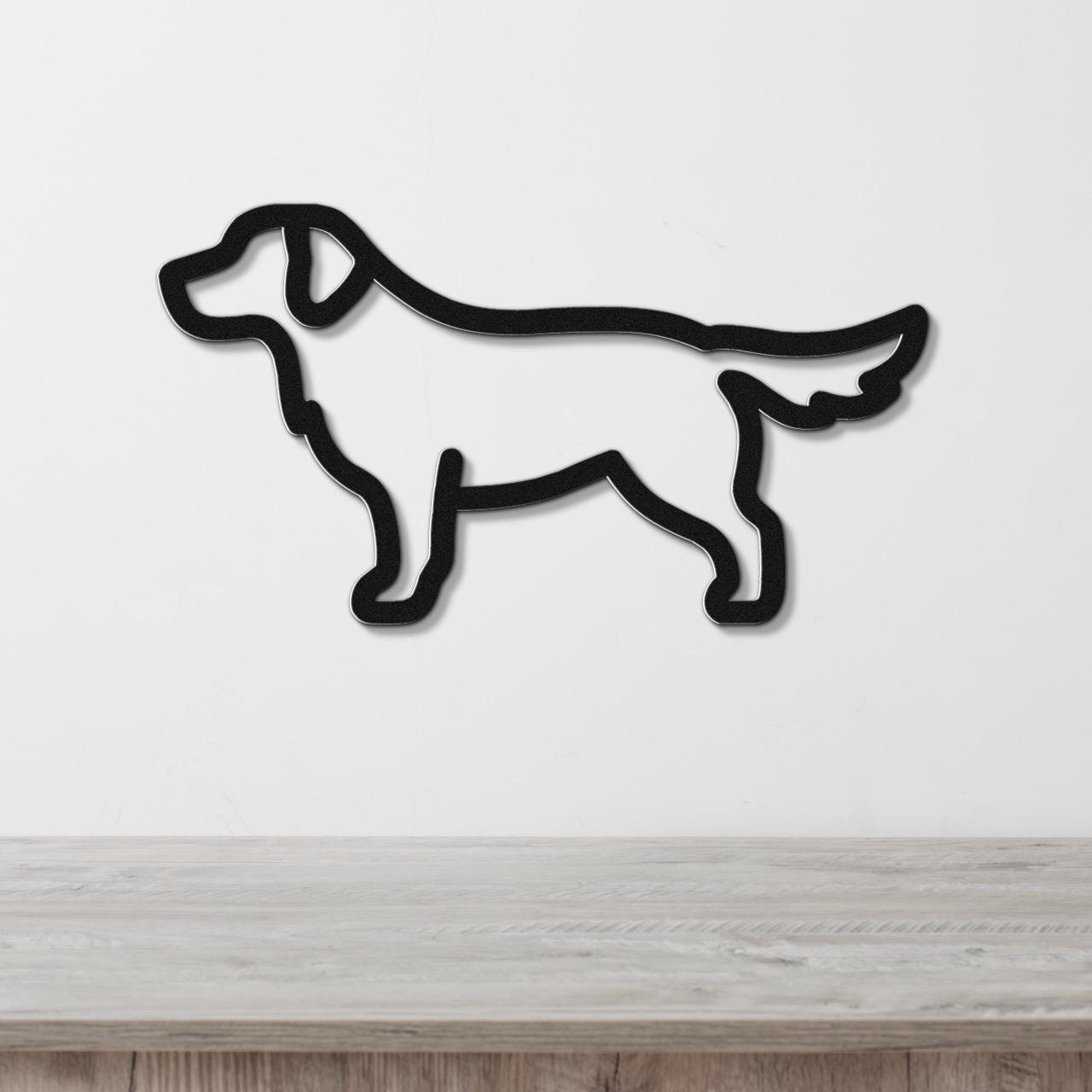 Black metal dog silhouette wall art in a golden retriever shape, mounted on a white wall above a light wood surface.