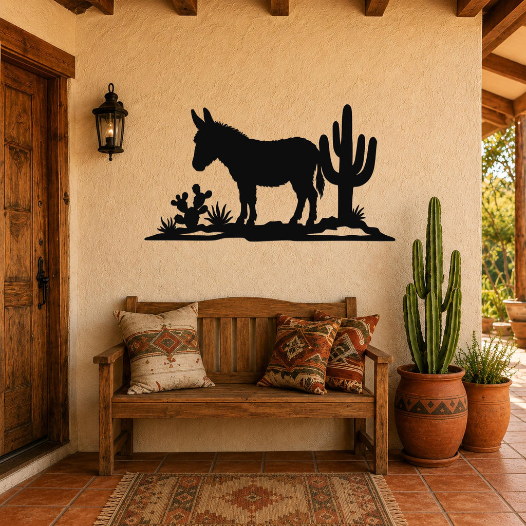 Black metal wall art silhouette of a burro and cacti, mounted on a stucco wall above a wooden bench in a rustic patio entry.