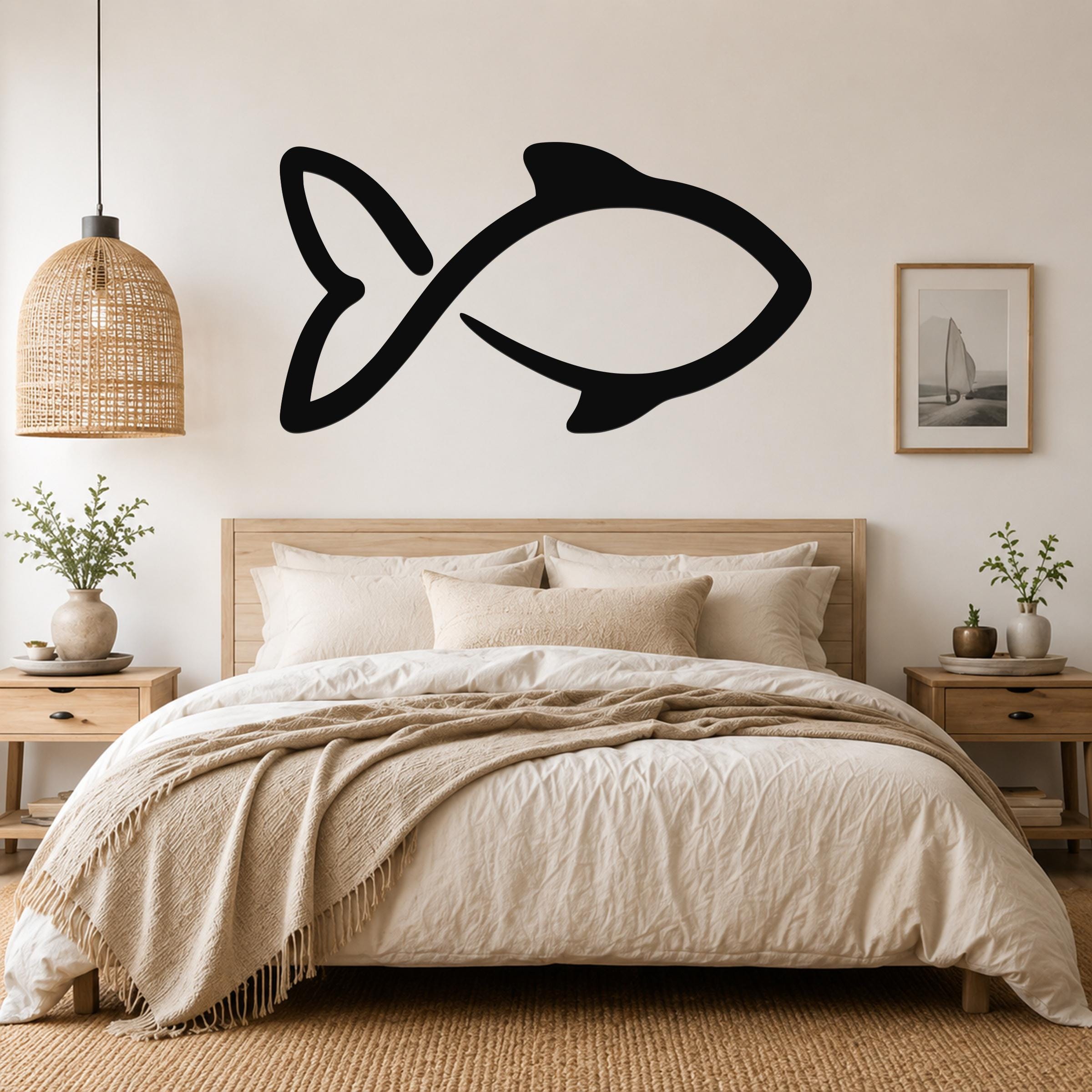 Black metal fish wall art with a simple silhouette design, mounted on a wall above a bed in a neutral bedroom.