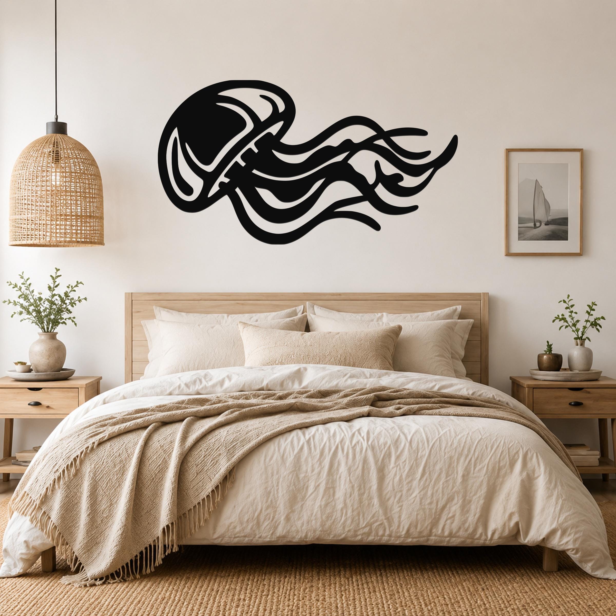 Black metal jellyfish wall art with flowing tentacle cutouts, mounted above a bed in a neutral bedroom.