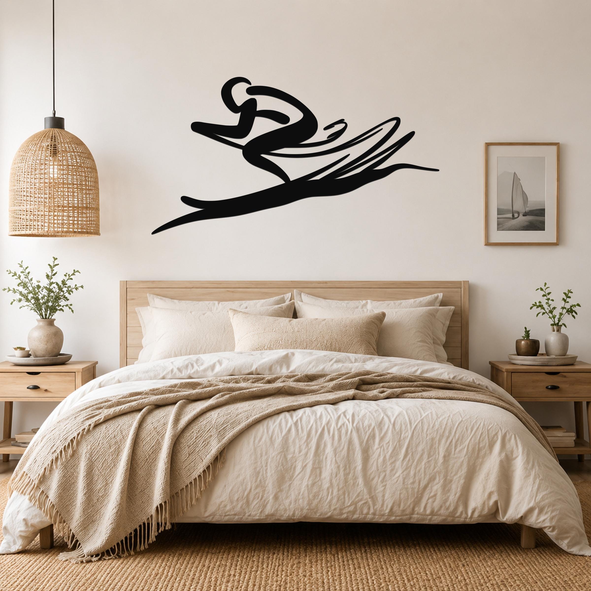 Black metal wall art in a dynamic skiing silhouette, mounted above a bed in a neutral bedroom.