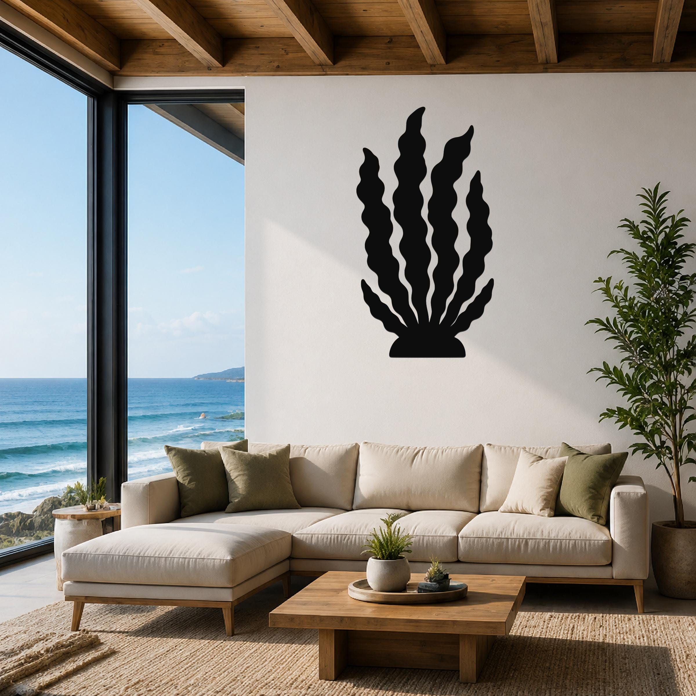 Black metal kelp wall art with wavy blade cutouts, mounted on a white living room wall above a beige sectional sofa.