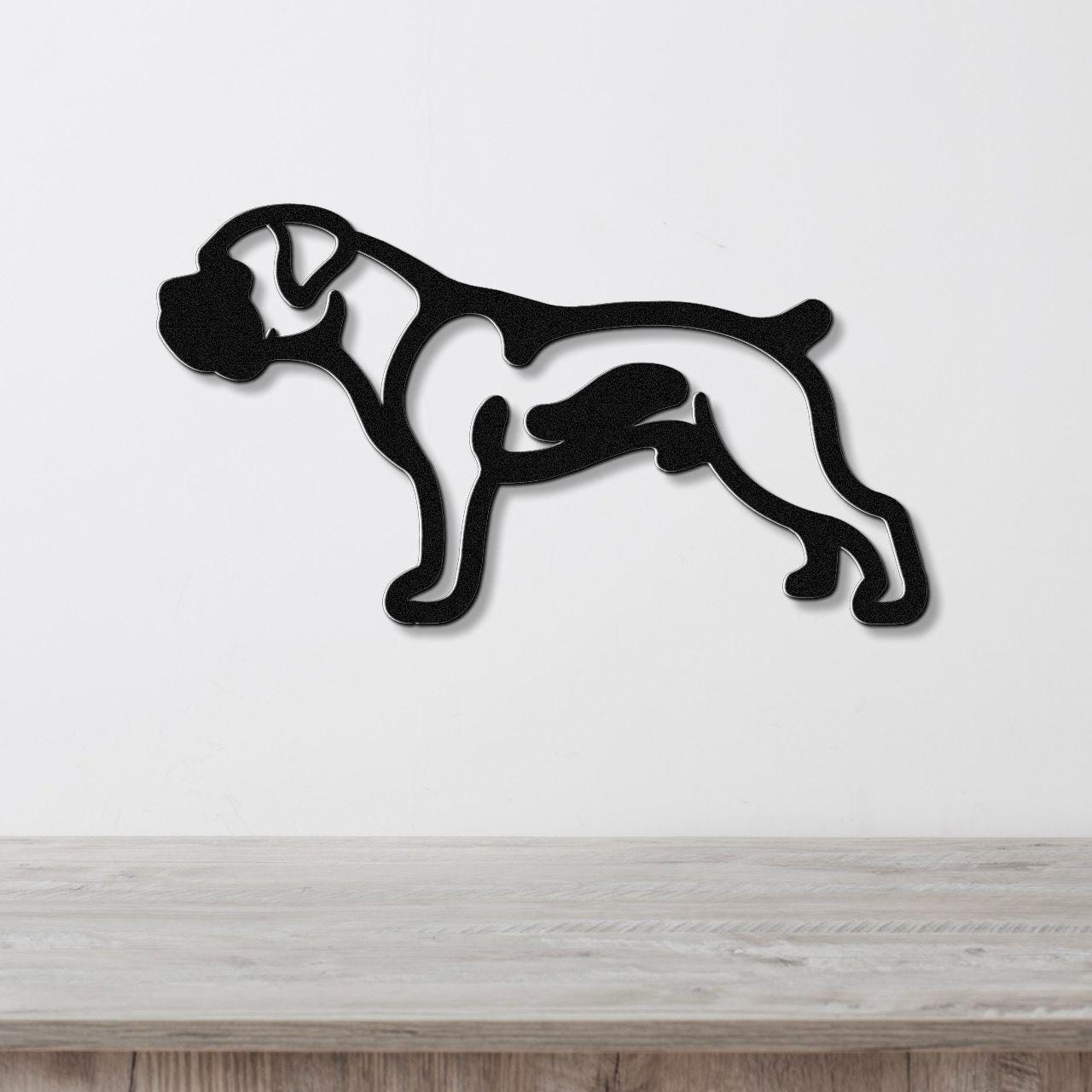 Black metal Boxer dog wall art in silhouette cutout style, mounted on a white wall above a light wood surface.