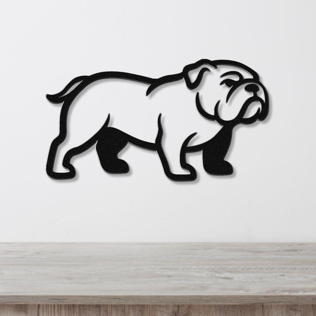 Black metal bulldog wall art silhouette with cutout details, mounted on a white wall above a light wood counter.
