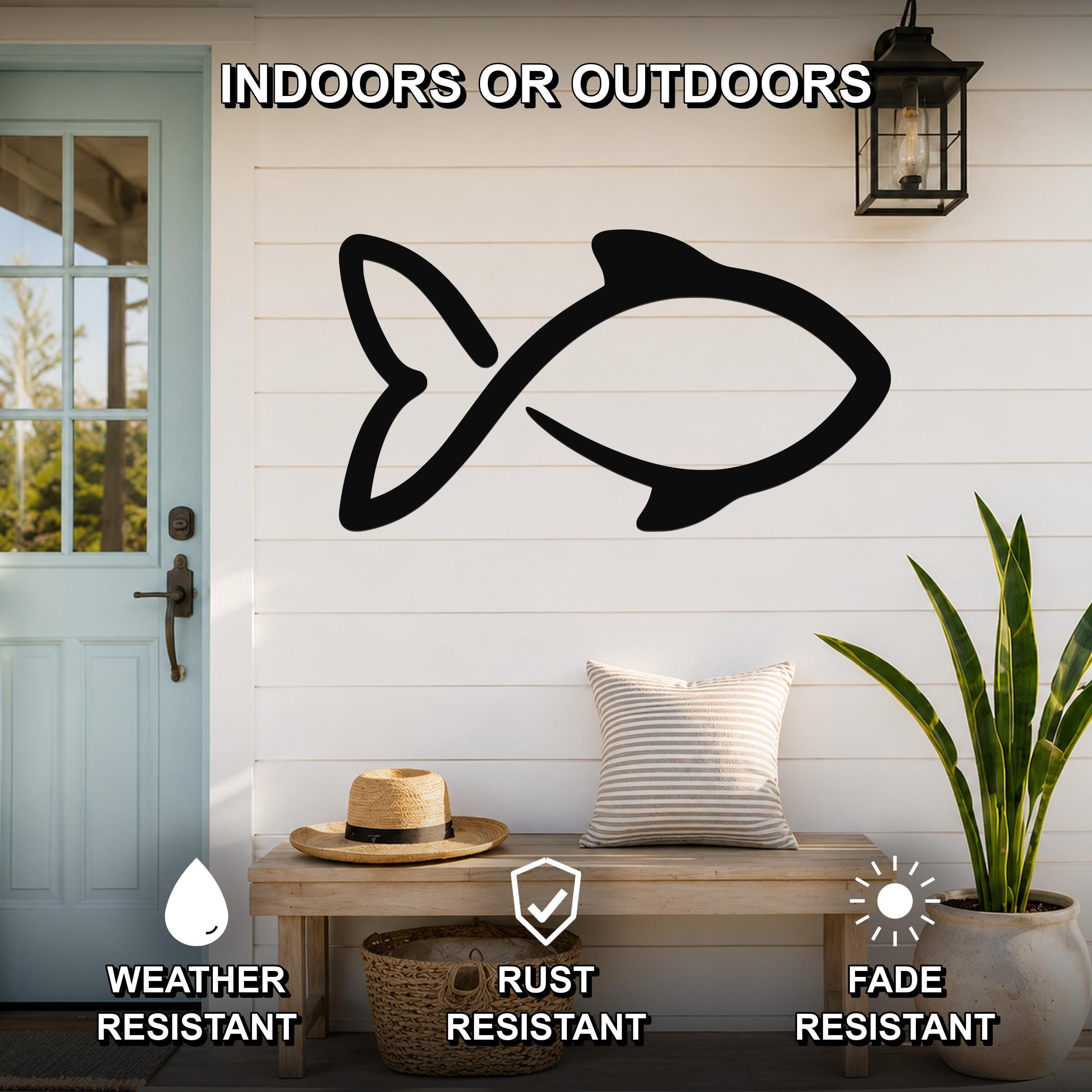 Black metal fish wall art silhouette mounted on a white shiplap wall above a wooden bench in a porch entryway.