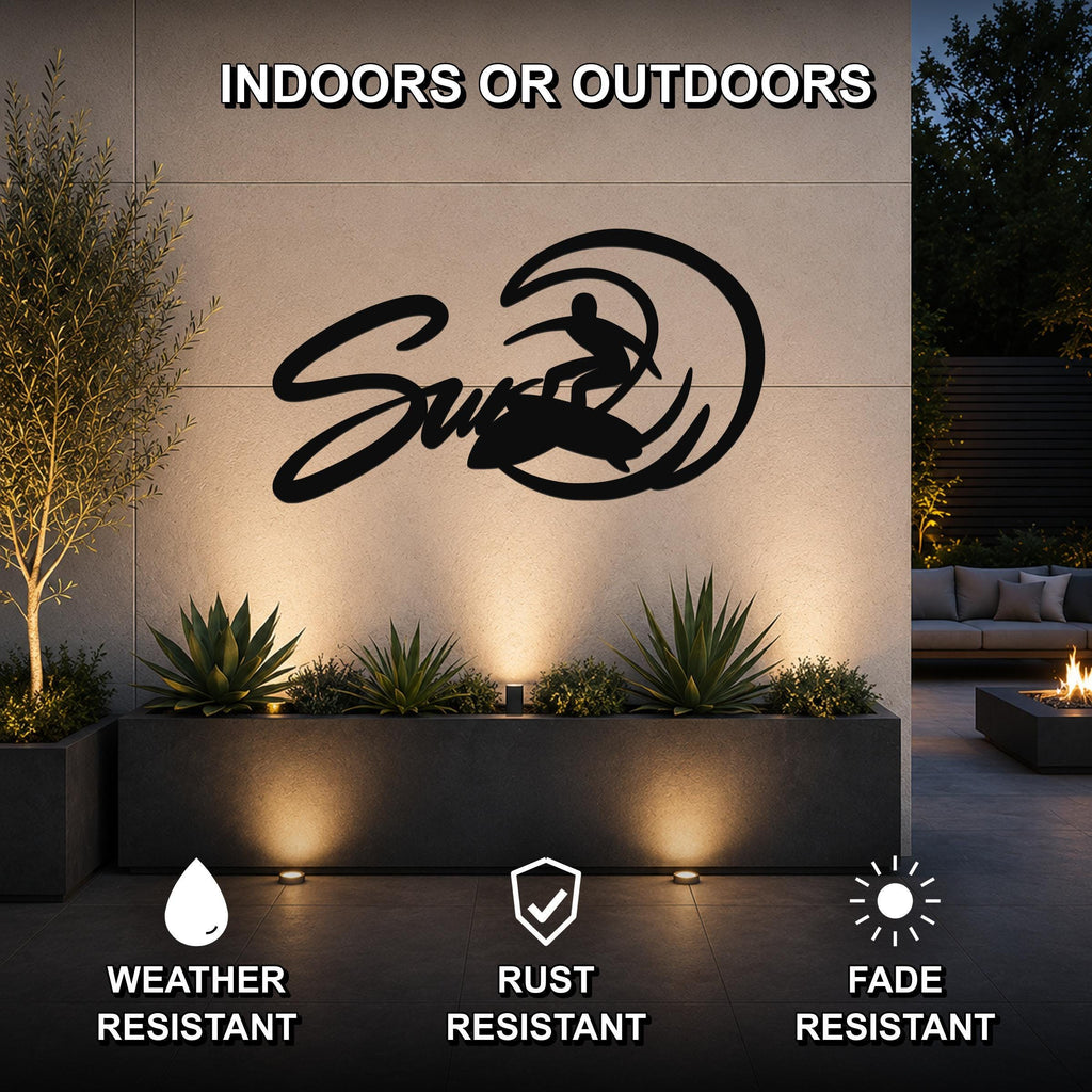 Black metal surfer silhouette wall art with wave cutout, mounted on an outdoor wall above a planter in a modern patio setting.