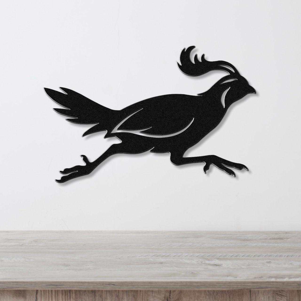 Black metal quail wall art in a running silhouette, mounted on a white wall above a light wood counter.