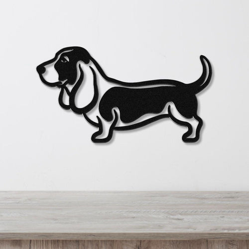 Black metal wall art silhouette of a basset hound, mounted on a white wall above a light wood surface.