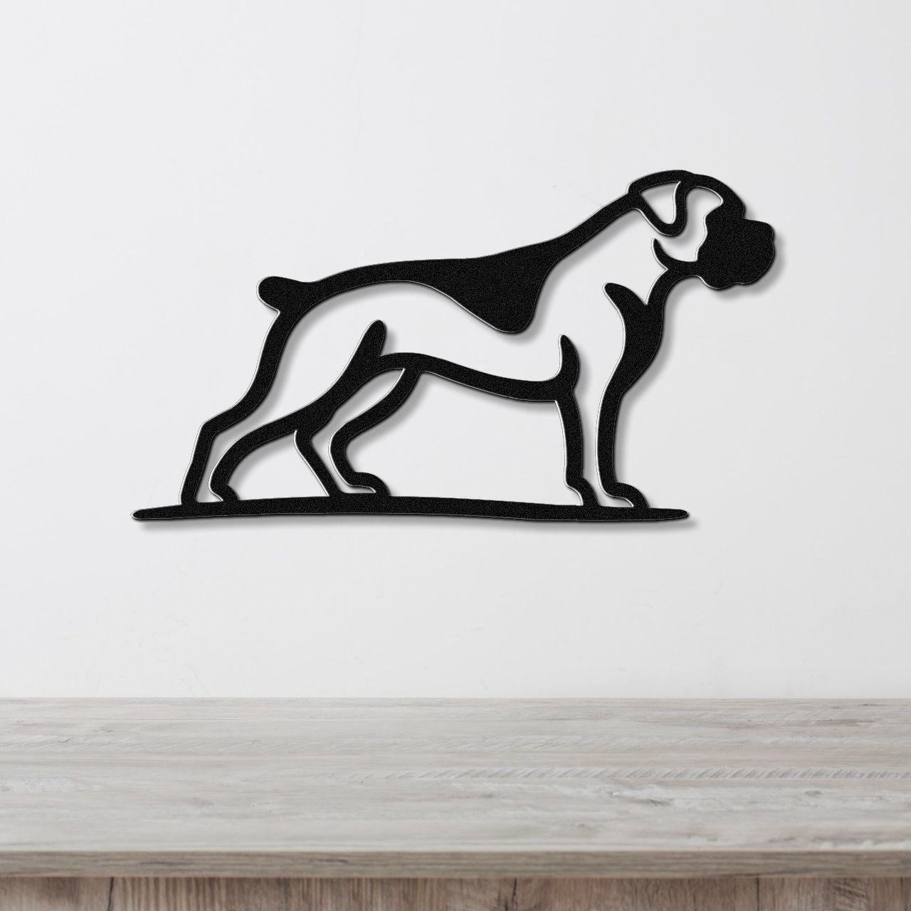 Black metal wall art silhouette of a boxer dog in profile, mounted on a white wall above a light wood surface.