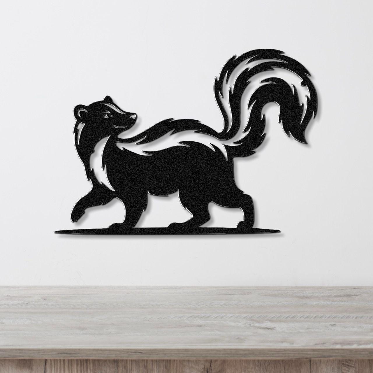 Black metal skunk wall art silhouette with a raised tail and white stripe, mounted on a white wall above a wooden surface.