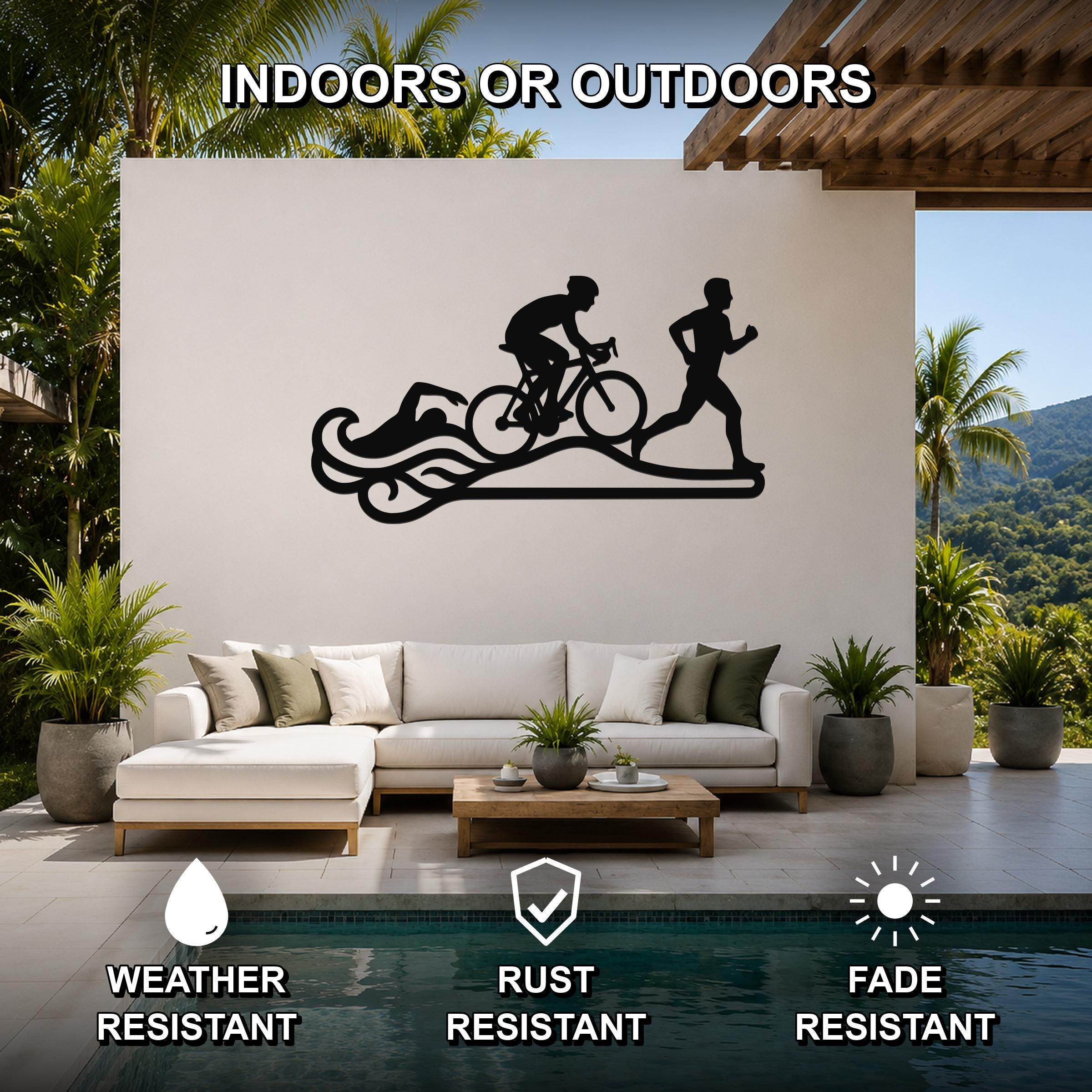 Black metal triathlon wall art with swim, bike, and run silhouettes and wave cutouts, mounted on a white outdoor patio wall above a sofa.