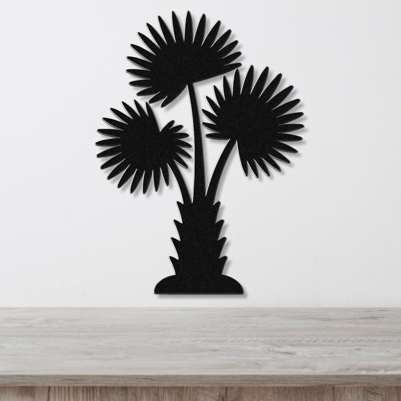 Black metal wall art cutout of a California fan palm tree with three fronds, mounted on a white wall above a light wood countertop.
