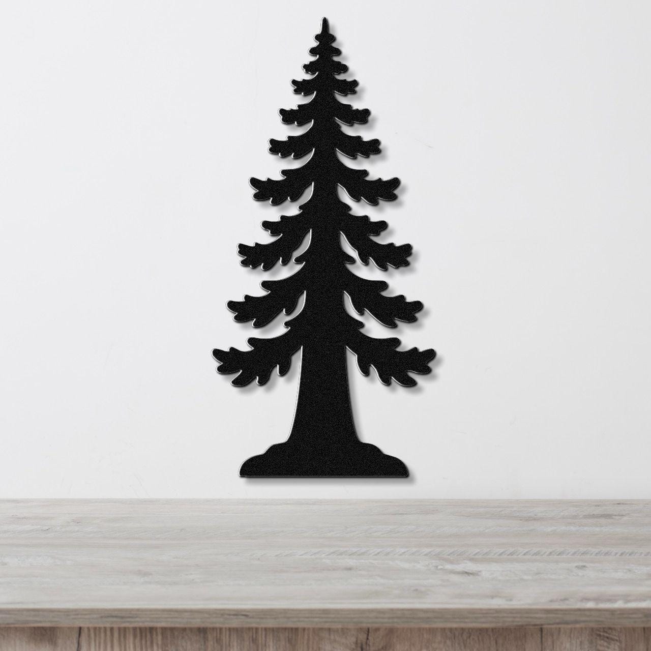 Black metal wall art in the silhouette of a sequoia tree with layered branch cutouts, mounted on a white wall above a light wood surface.
