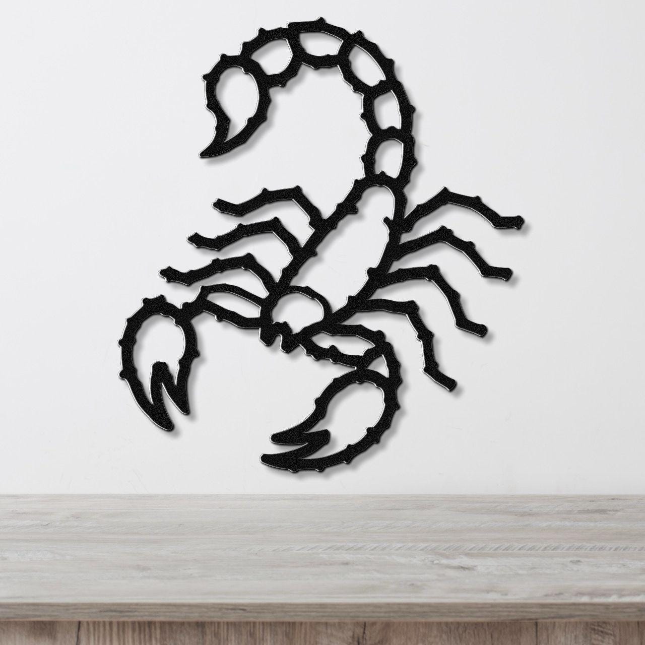 Black metal scorpion wall art with detailed cutout segments, mounted on a white wall above a light wood surface.