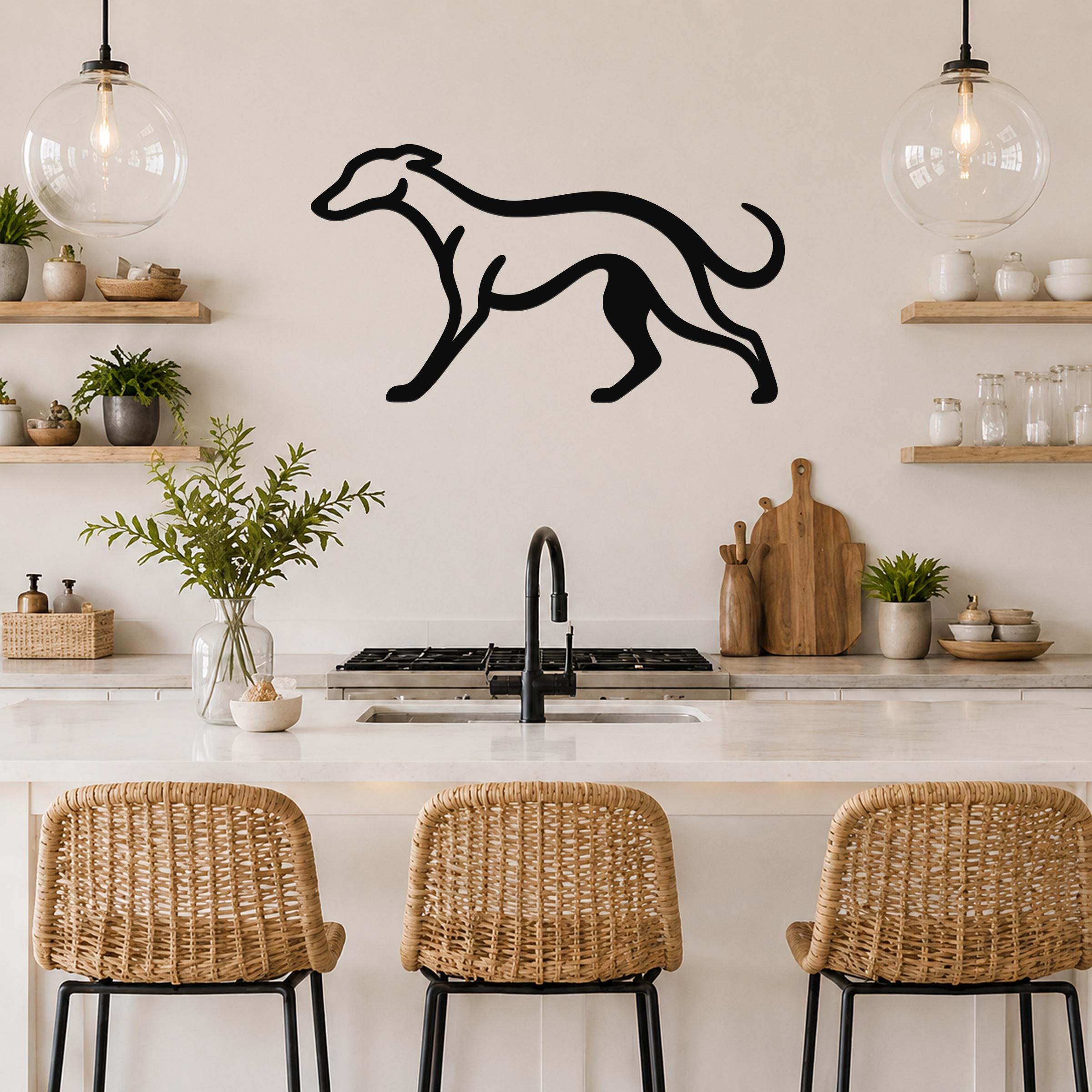 Black metal greyhound wall art silhouette mounted above a kitchen counter, displayed between two glass pendant lights and wooden shelves.
