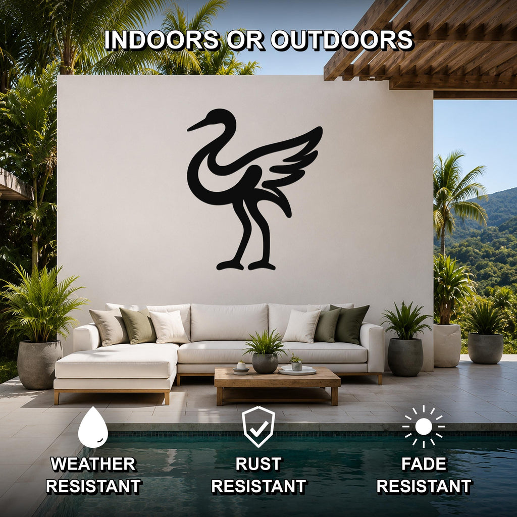 Black metal crane wall art with a silhouette design, mounted on a white outdoor wall above a sofa in a patio living area.