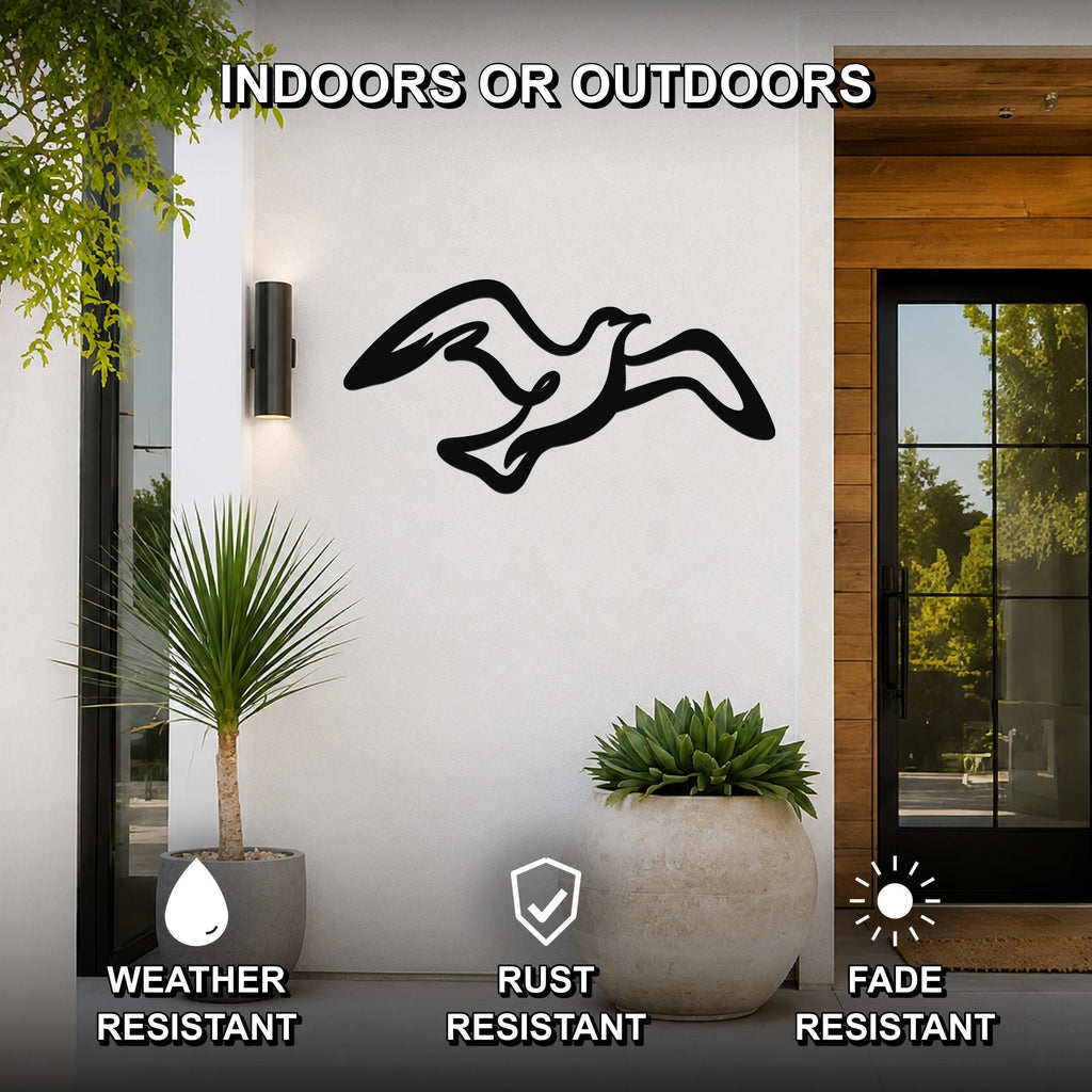 Black metal seagull wall art with motion-line cutouts, mounted on a white exterior wall beside a glass door and potted plants.