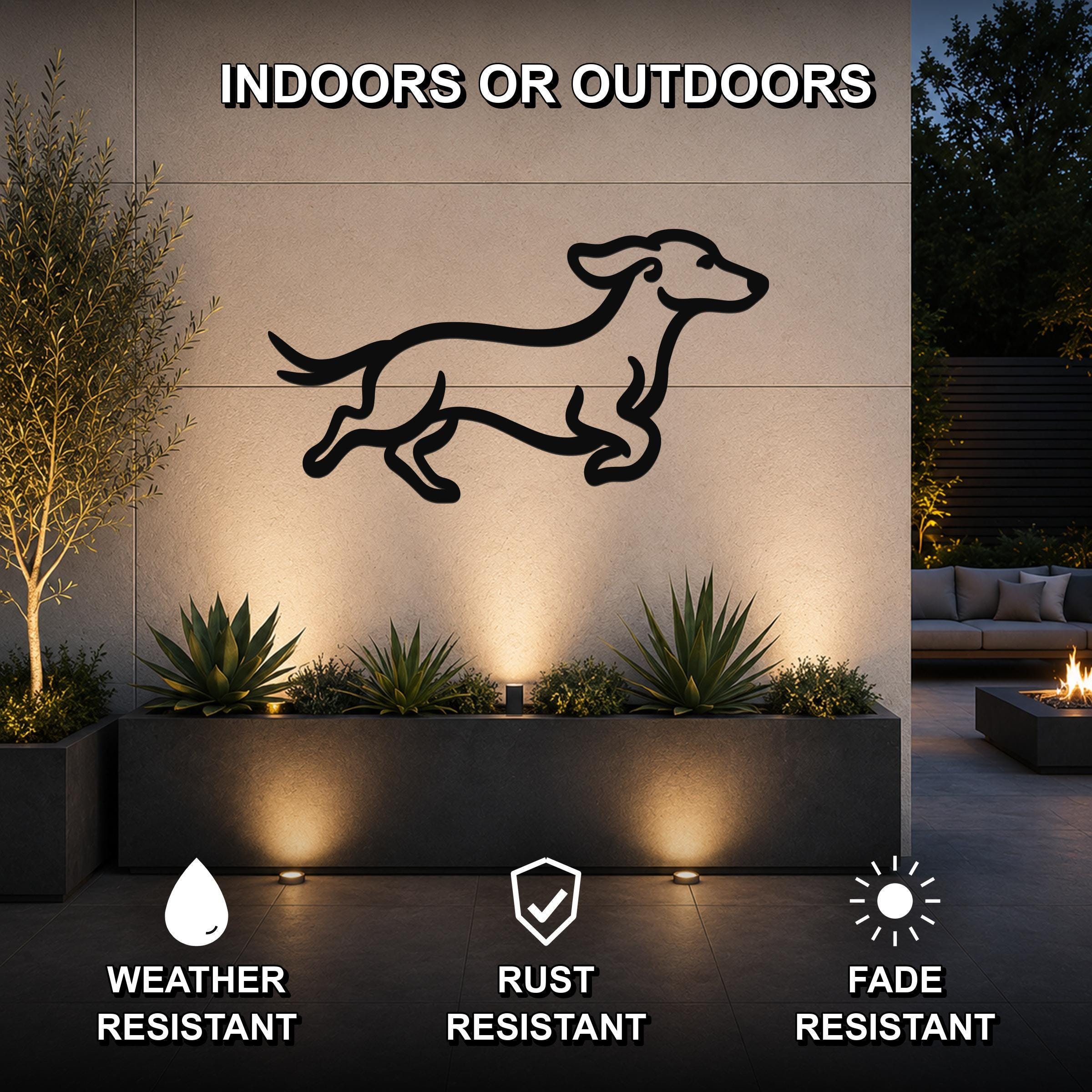 Black metal dachshund wall art with motion-line cutouts, mounted on an outdoor wall above a planter in a modern patio setting.