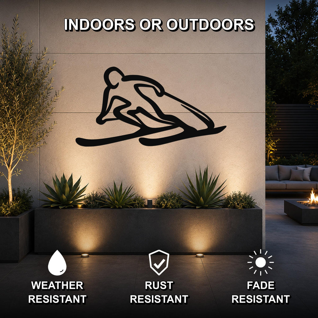 Black metal skier silhouette wall art mounted on an outdoor wall above a planter, with text indicating it is weather, rust, and fade resistant for indoor or outdoor use.