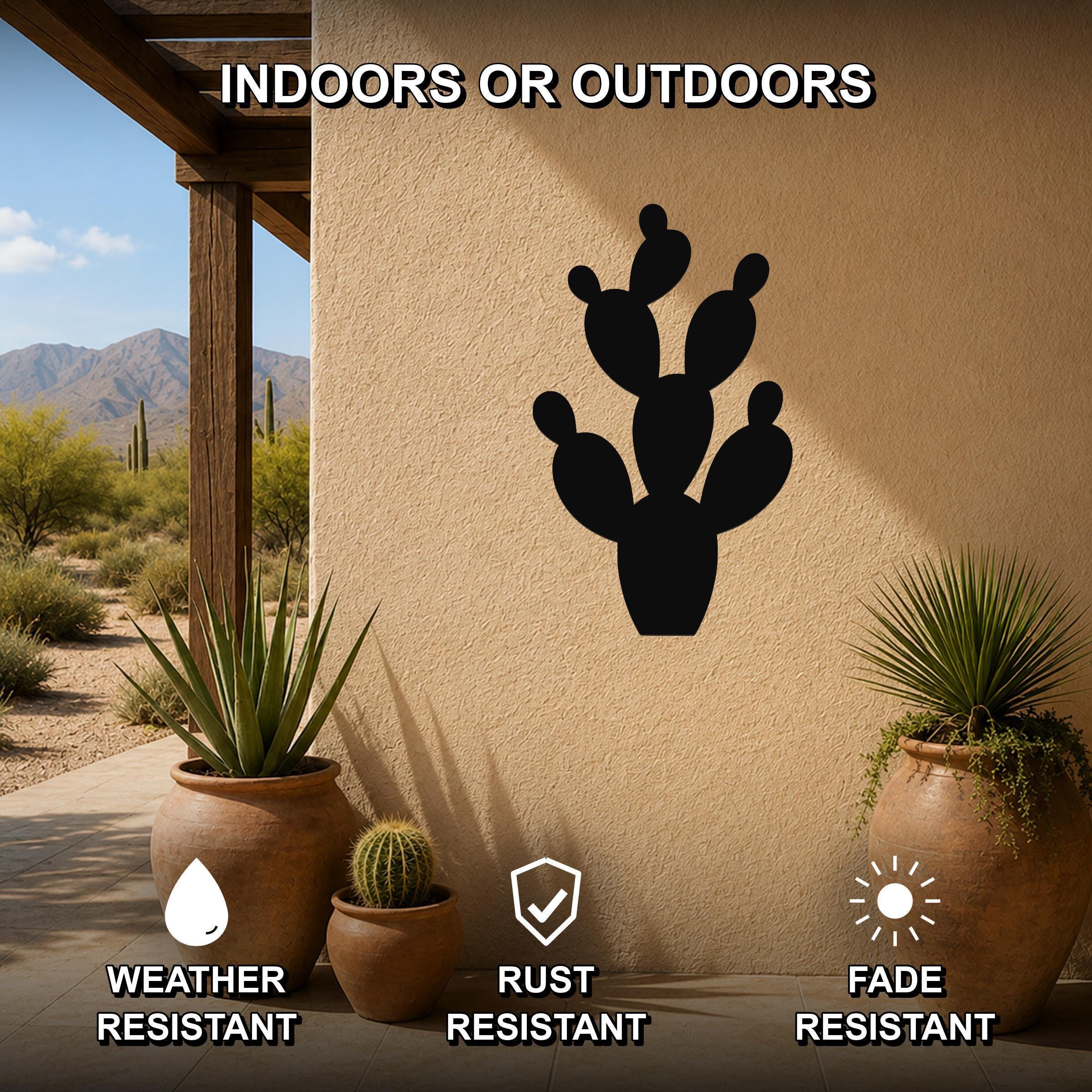Black metal prickly pear cactus wall art with cutout details, mounted on an outdoor patio wall above potted plants.