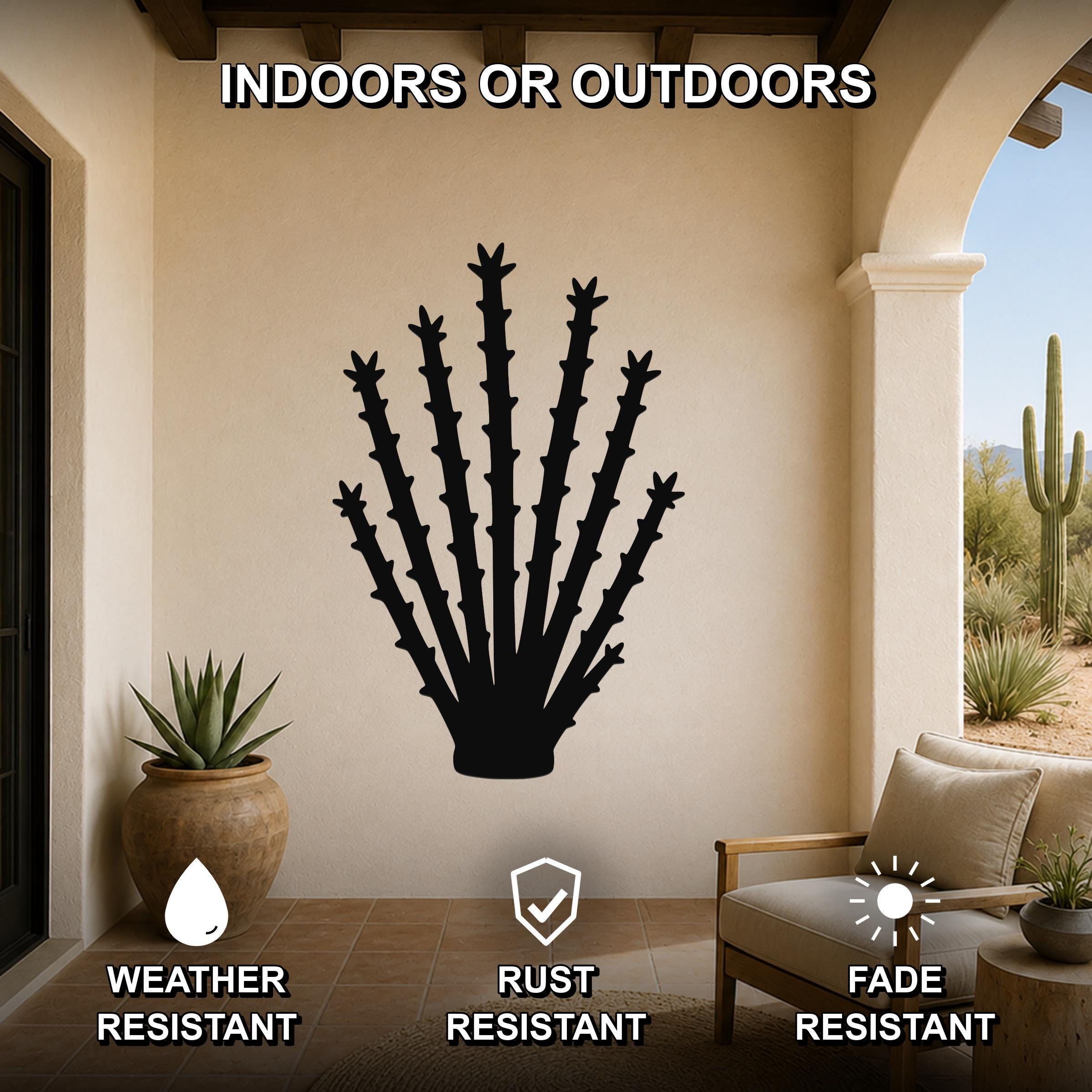 Black metal ocotillo wall art silhouette with spiky branches, mounted on a beige patio wall above a wooden chair in a covered outdoor living space.