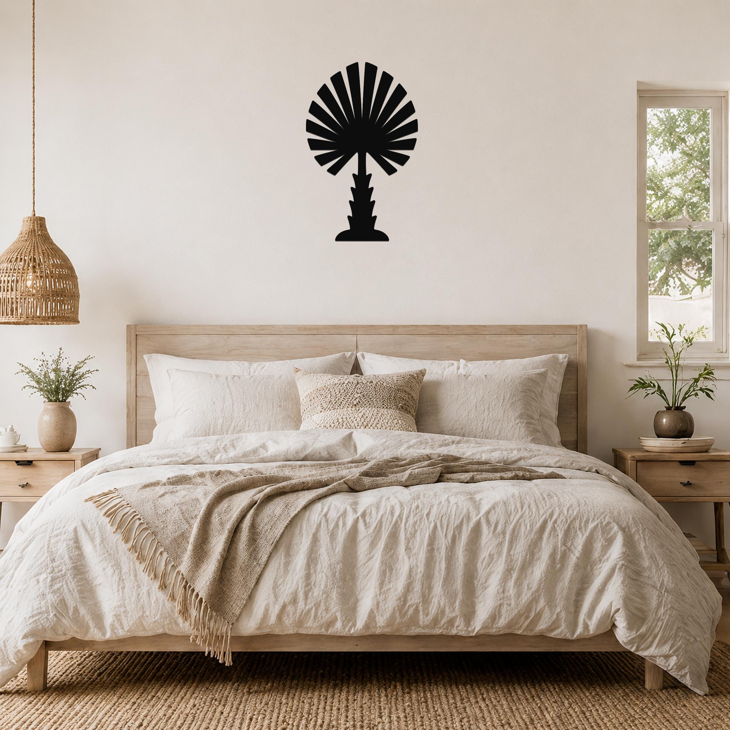 Black metal palm tree wall art with fan-shaped fronds, mounted above a wooden bed in a neutral bedroom.