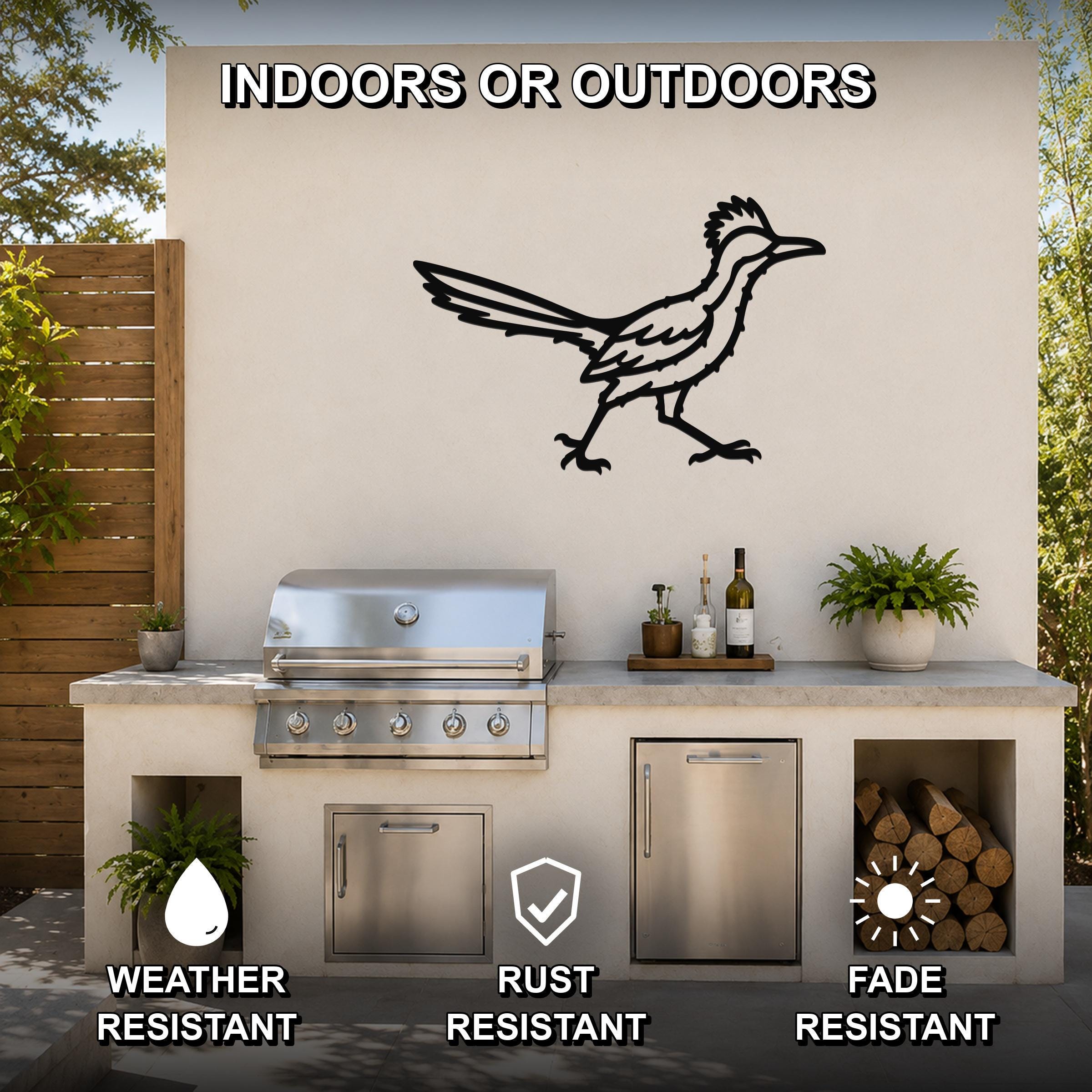 Black metal roadrunner wall art with motion-line cutouts, mounted on an outdoor patio wall above a grill and counter.