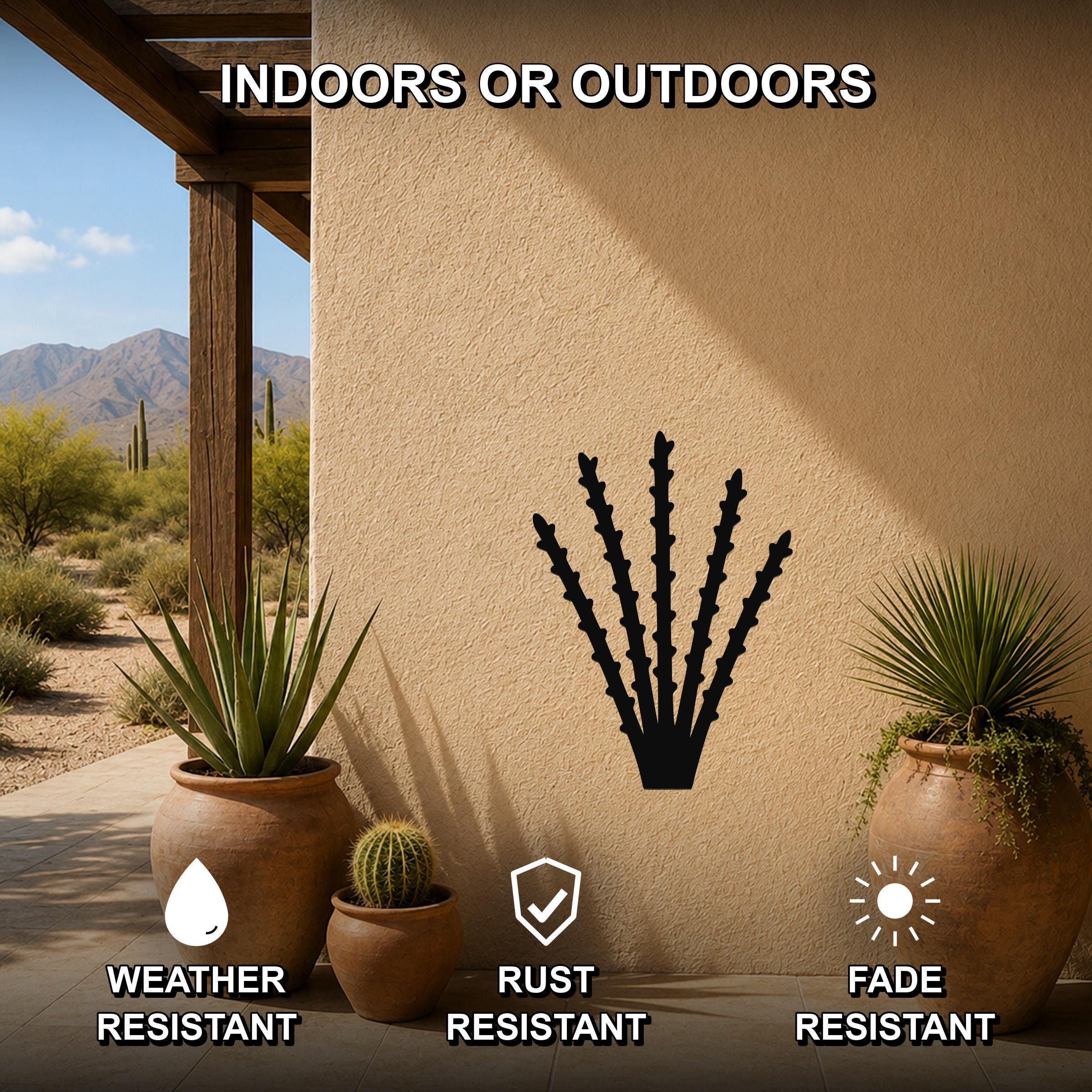 Black metal ocotillo wall art silhouette mounted on a beige outdoor wall, displayed on a patio with potted plants and desert scenery in the background.