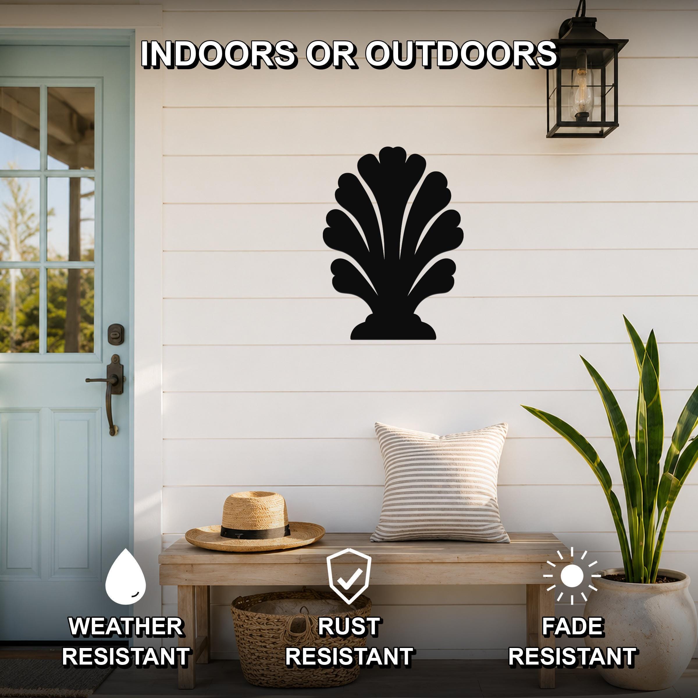 Black metal coral wall art with scalloped cutouts, mounted on a white shiplap wall above a wooden bench in a coastal entryway.