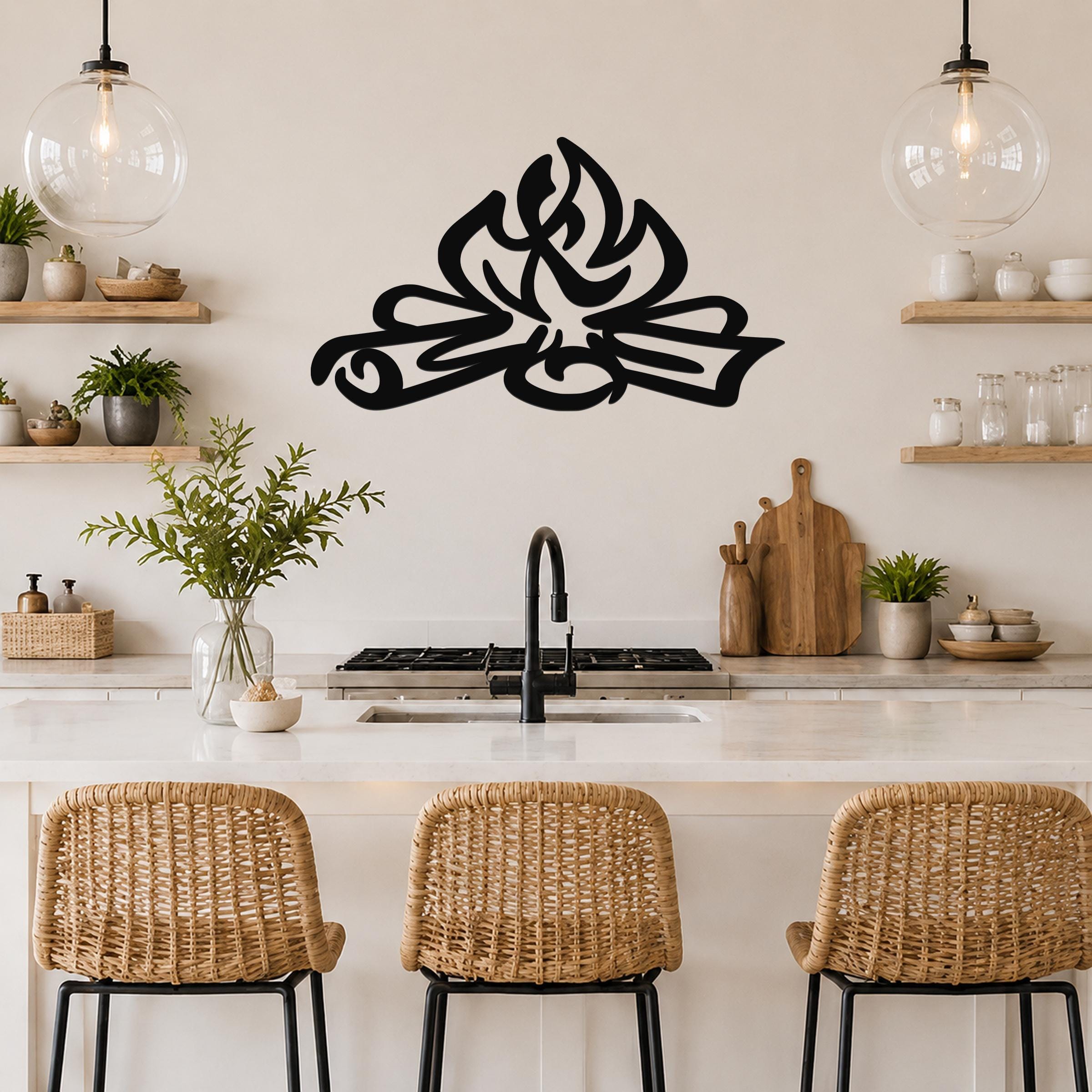 Black metal wall art in a flame silhouette design, mounted above a kitchen counter with wicker bar stools and open shelving.