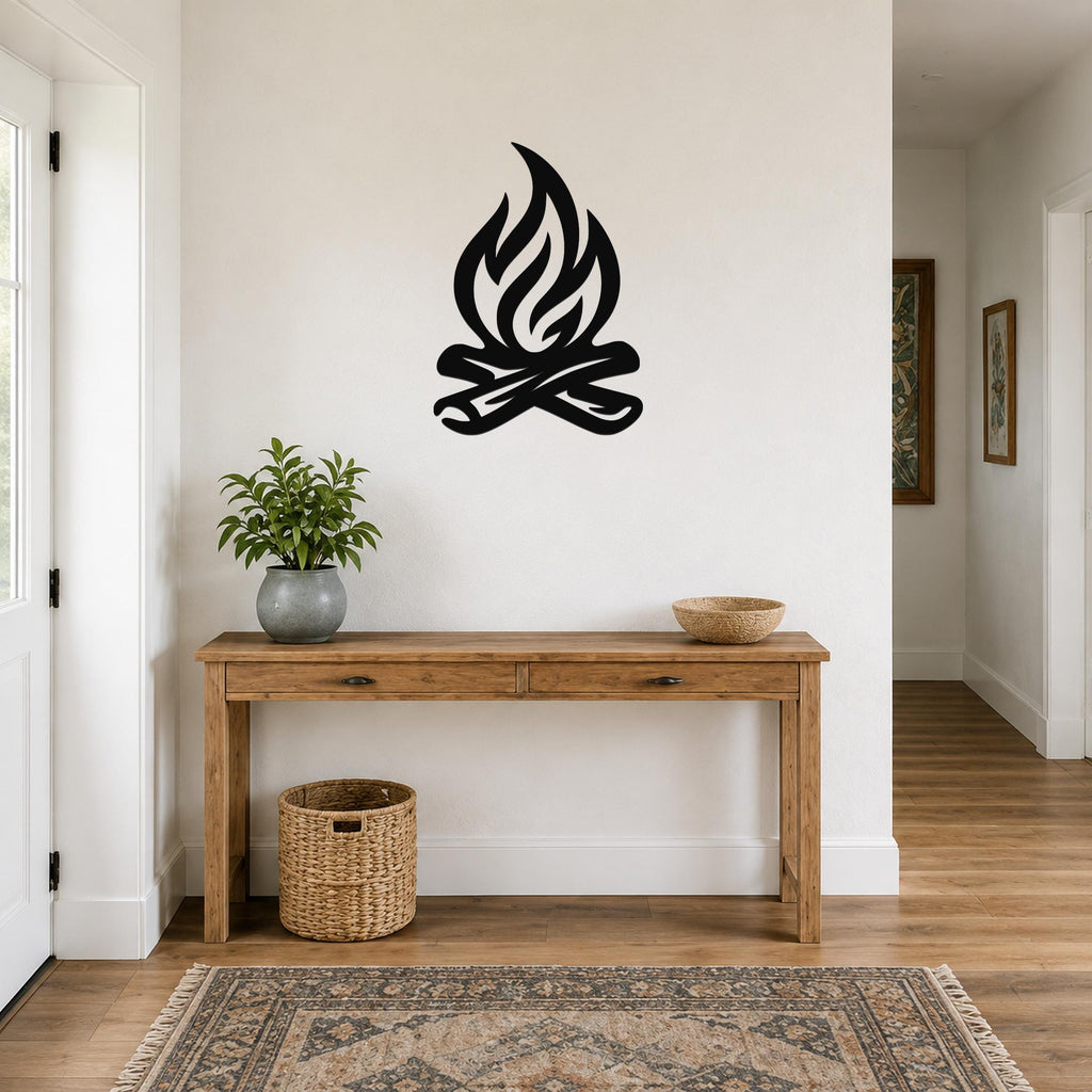 Black metal campfire wall art with flame and log silhouette, mounted above a wooden console table in a hallway.