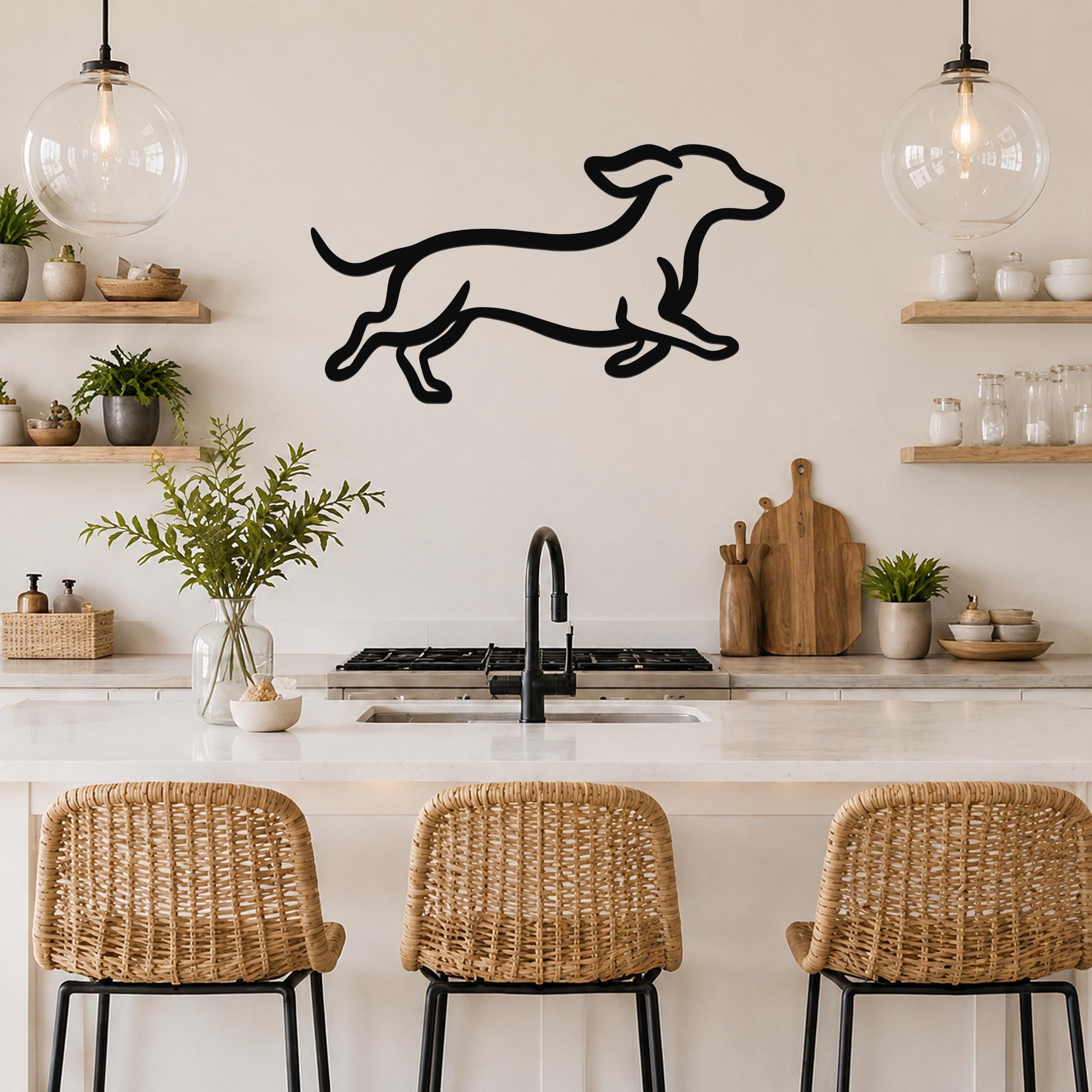 Black metal dachshund wall art with a running silhouette, mounted on a kitchen wall above a counter.