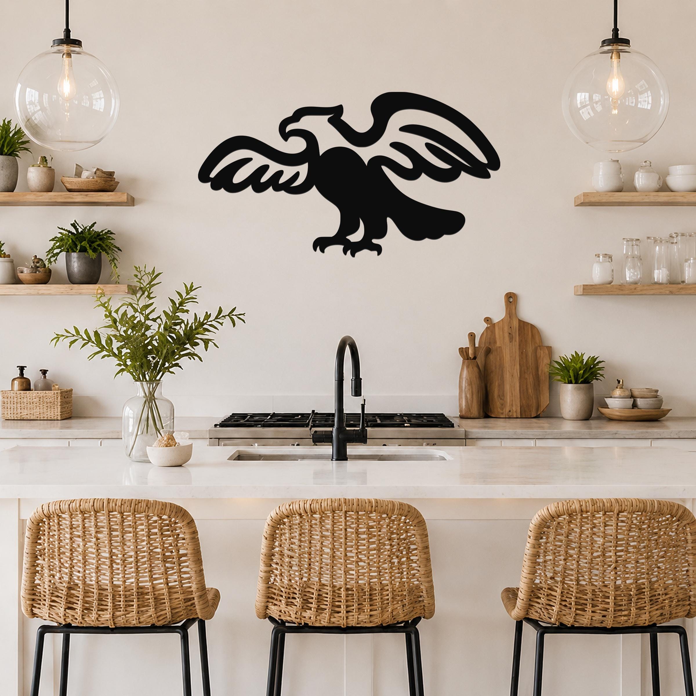 Black metal eagle wall art with outstretched wings and detailed feather cutouts, mounted on a kitchen wall above a counter.