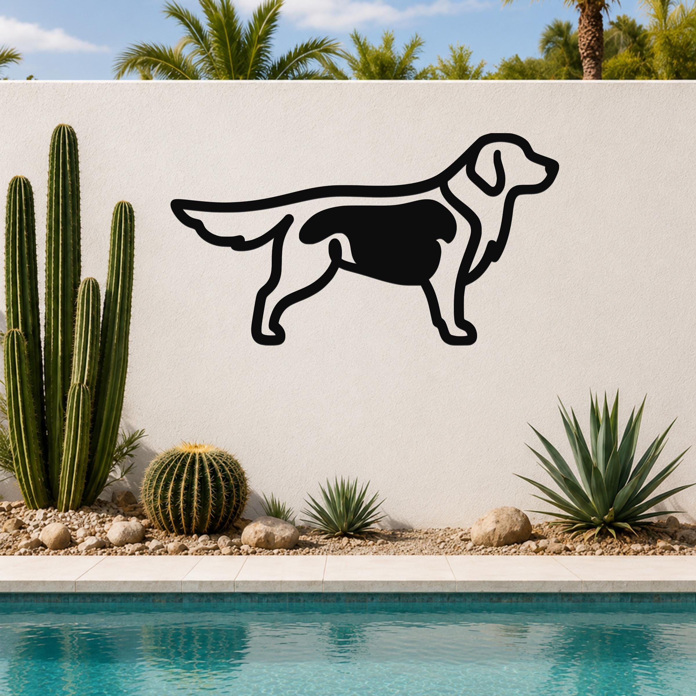 Black metal dog silhouette wall art with internal cutout details, mounted on an outdoor wall beside a pool and cacti.