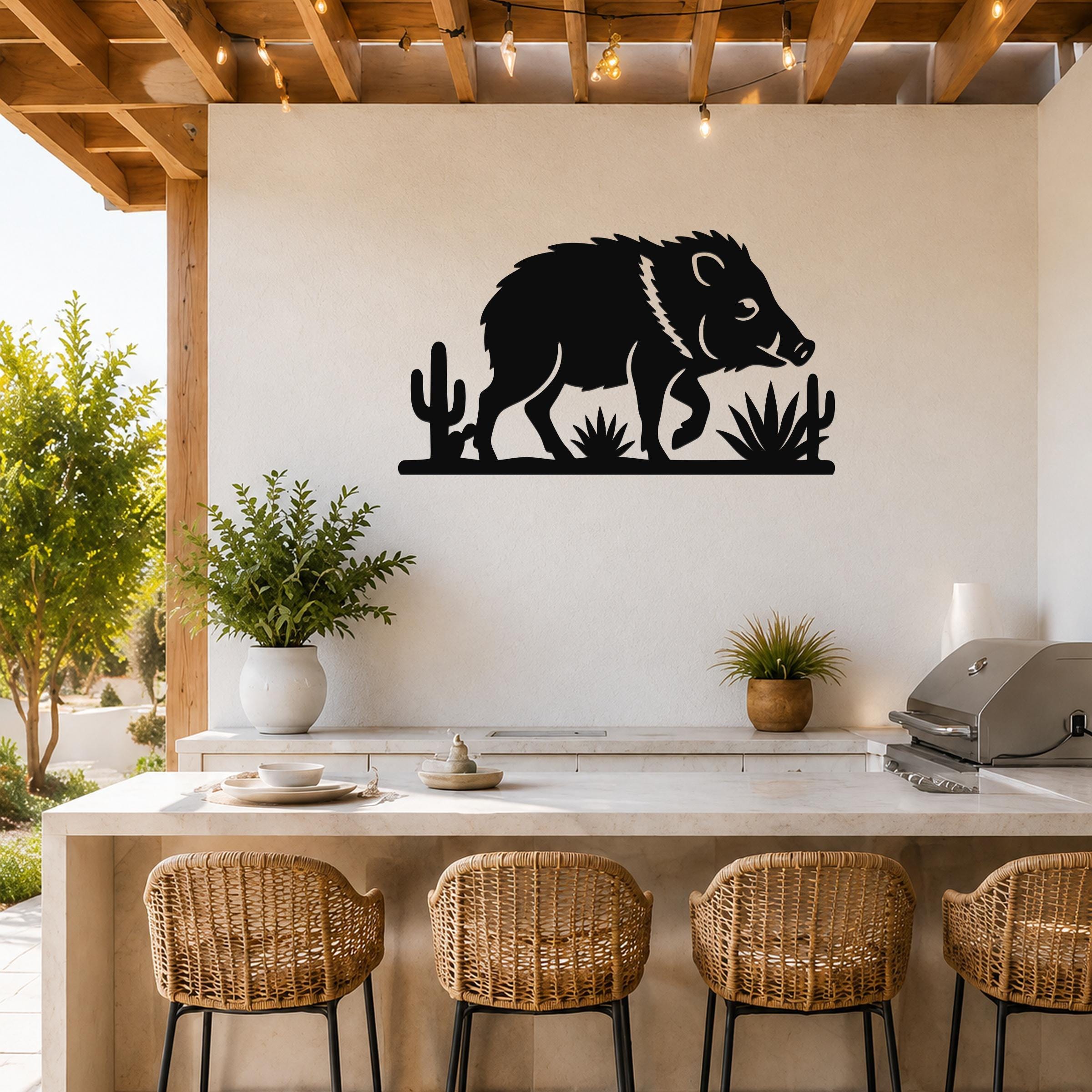 Black metal wall art silhouette of a javelina with cacti and agave, mounted on a white wall above a kitchen counter.