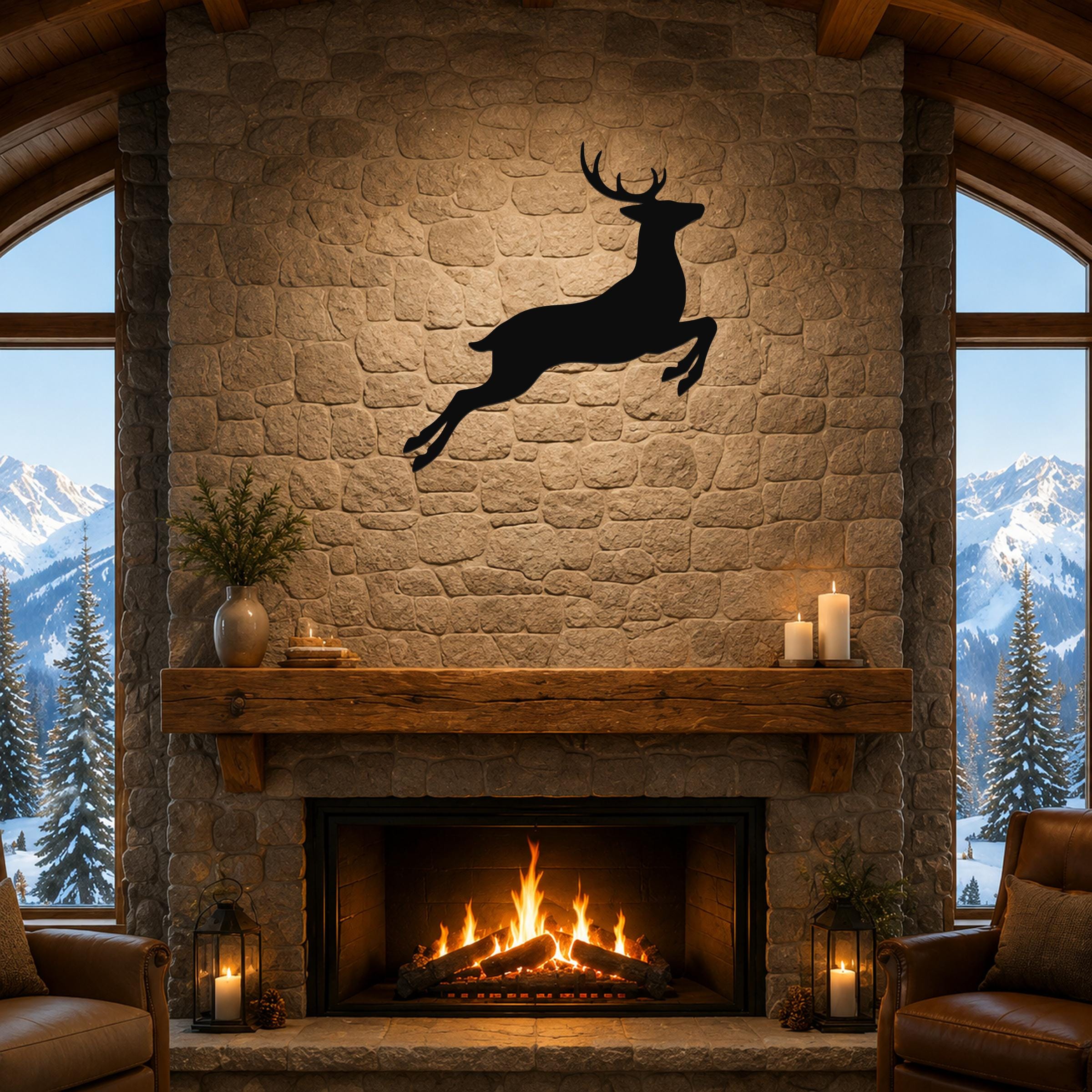 Black metal jumping deer wall art silhouette mounted above a stone fireplace in a rustic living room with mountain views.