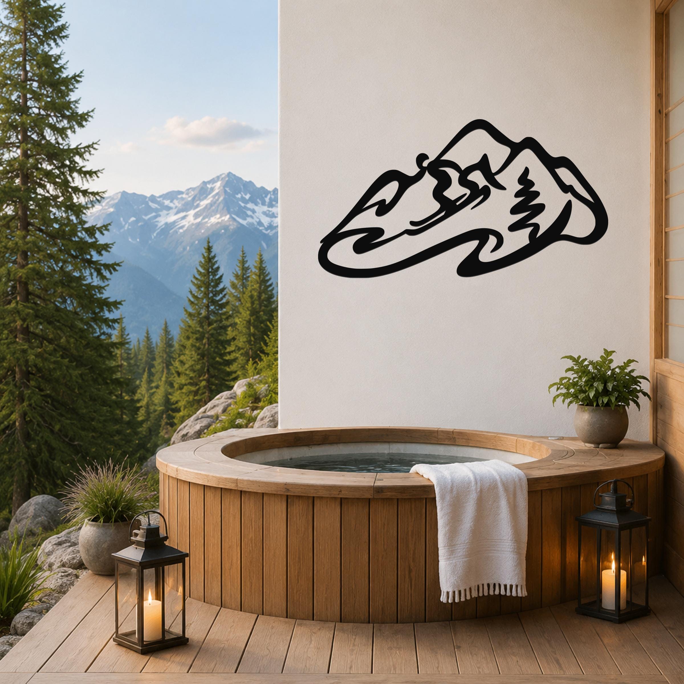 Black metal wall art of a minimalist skier silhouette, mounted on a white wall above a wooden hot tub on a deck with mountain views.