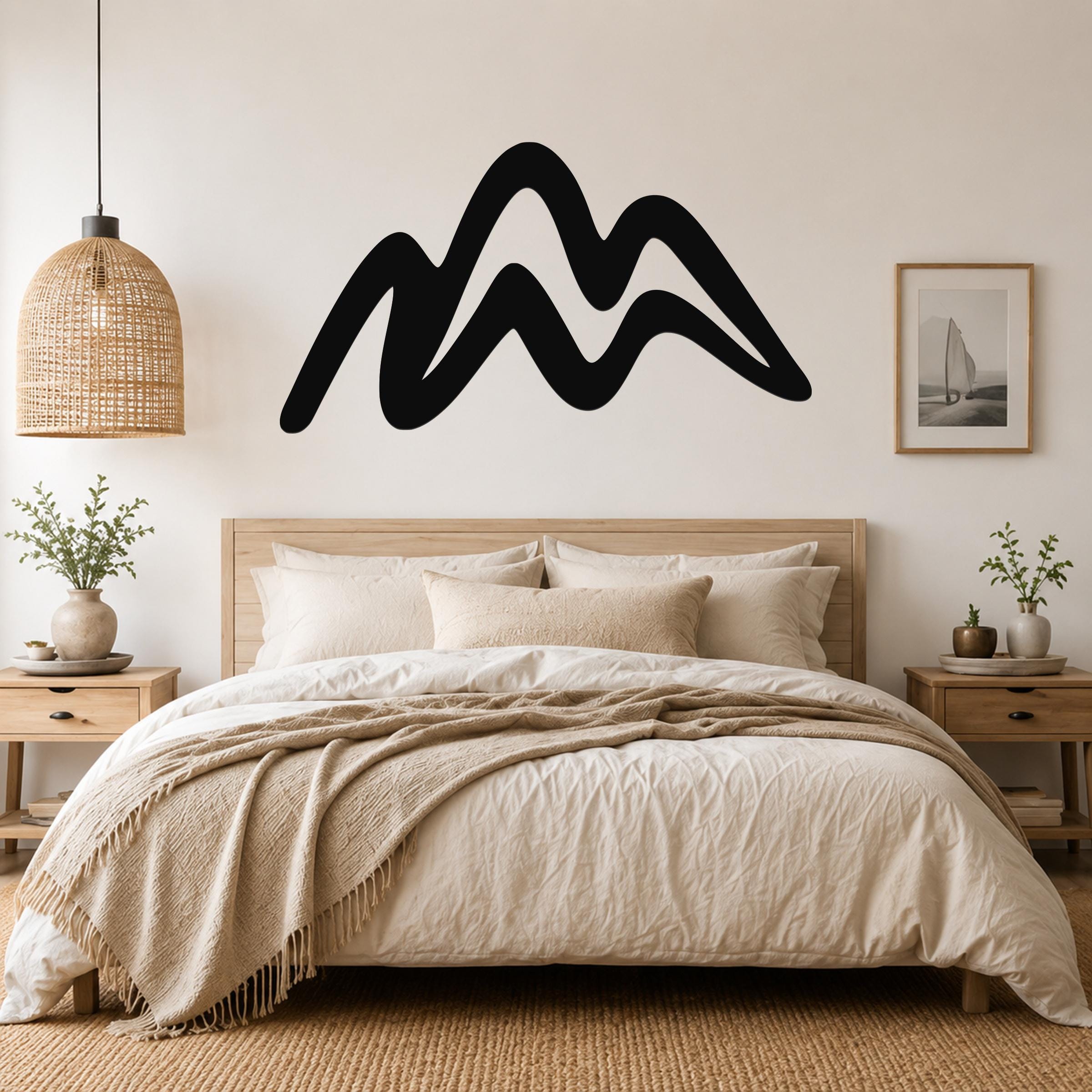 Black metal mountain silhouette wall art with flowing wave-like peaks, mounted above a wooden bed in a neutral bedroom.