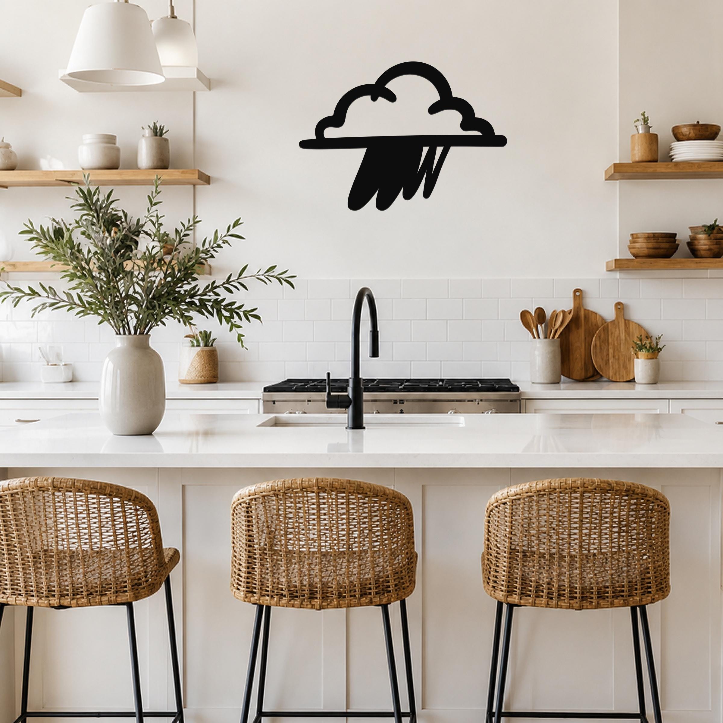 Black metal rain cloud wall art with raindrop cutouts, mounted on a kitchen wall above a white countertop.