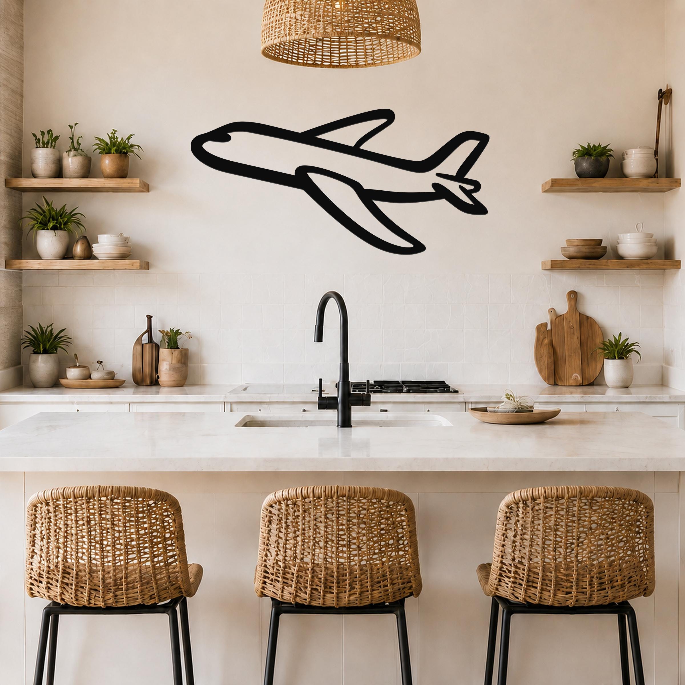 Black metal airplane wall art with a bold silhouette design, mounted on a kitchen wall above a counter with wicker bar stools.