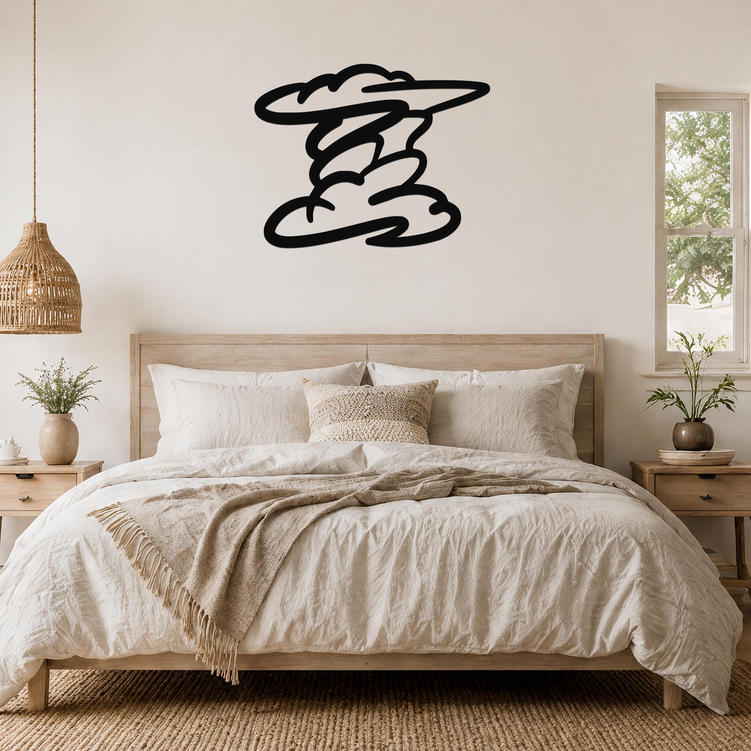 Black metal wall art in a cloud silhouette shape, mounted above a wooden bed in a neutral bedroom.