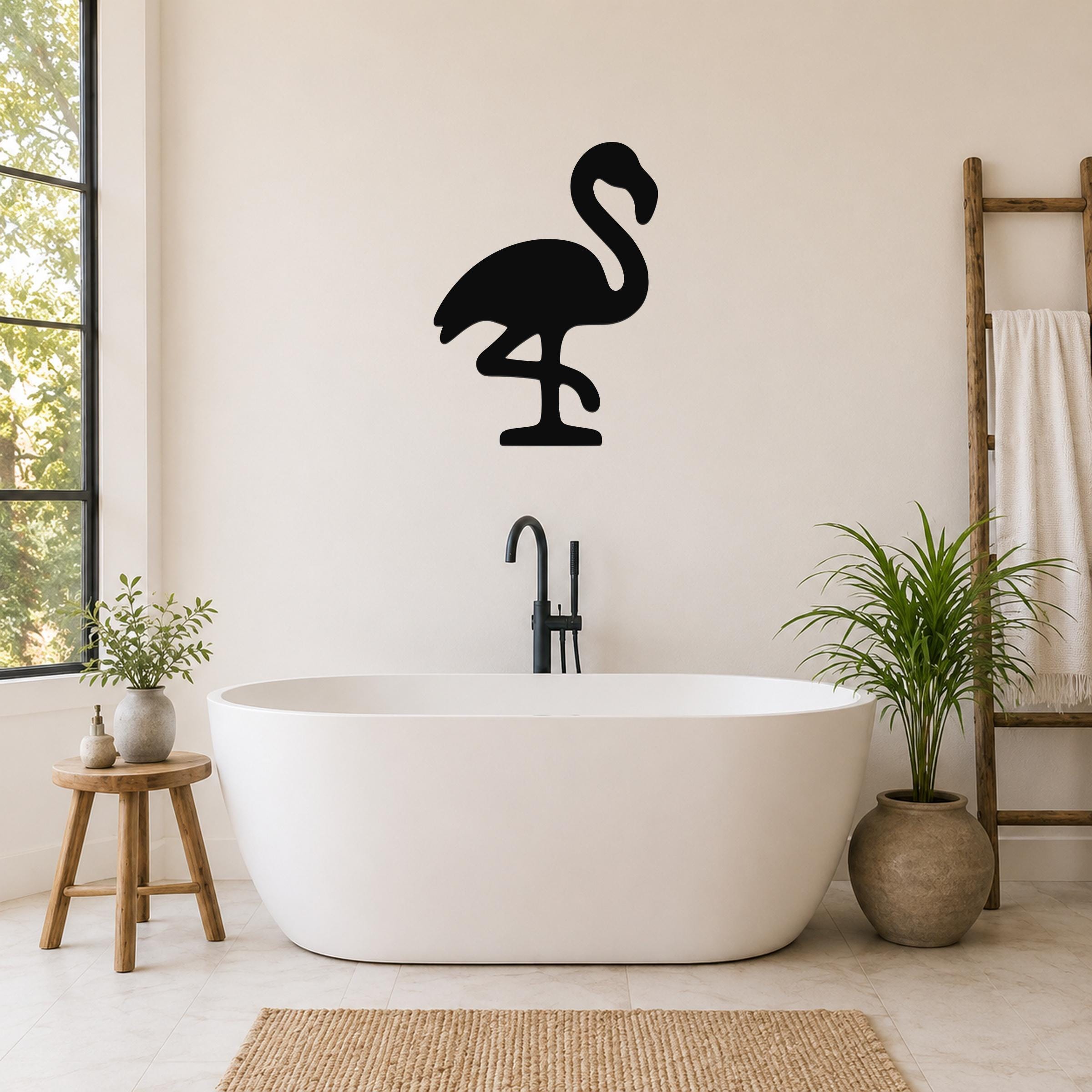Black metal flamingo wall art silhouette mounted on a bathroom wall above a freestanding tub.