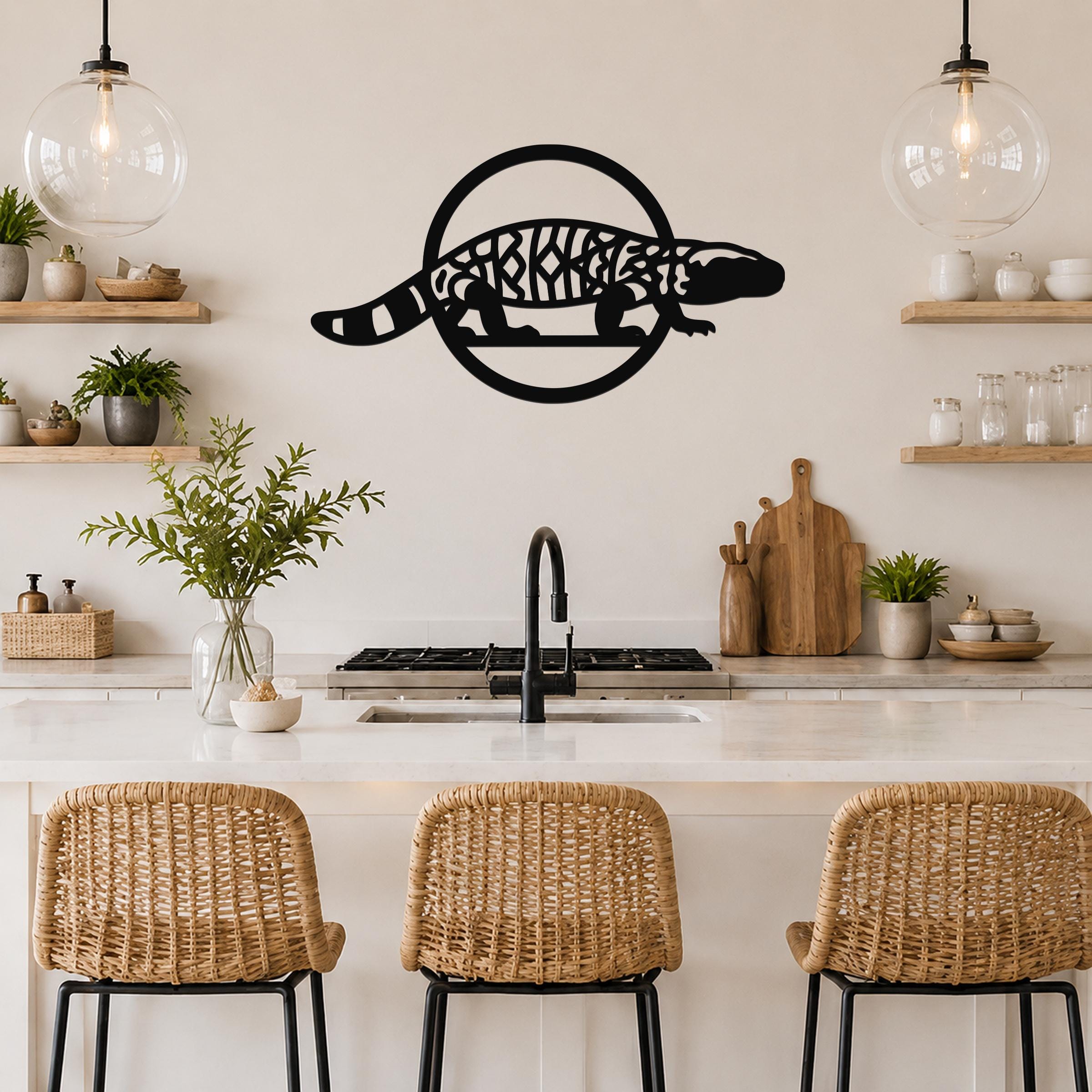 Black metal wall art featuring a Gila monster silhouette with intricate internal cutouts, mounted on a kitchen wall above a counter.
