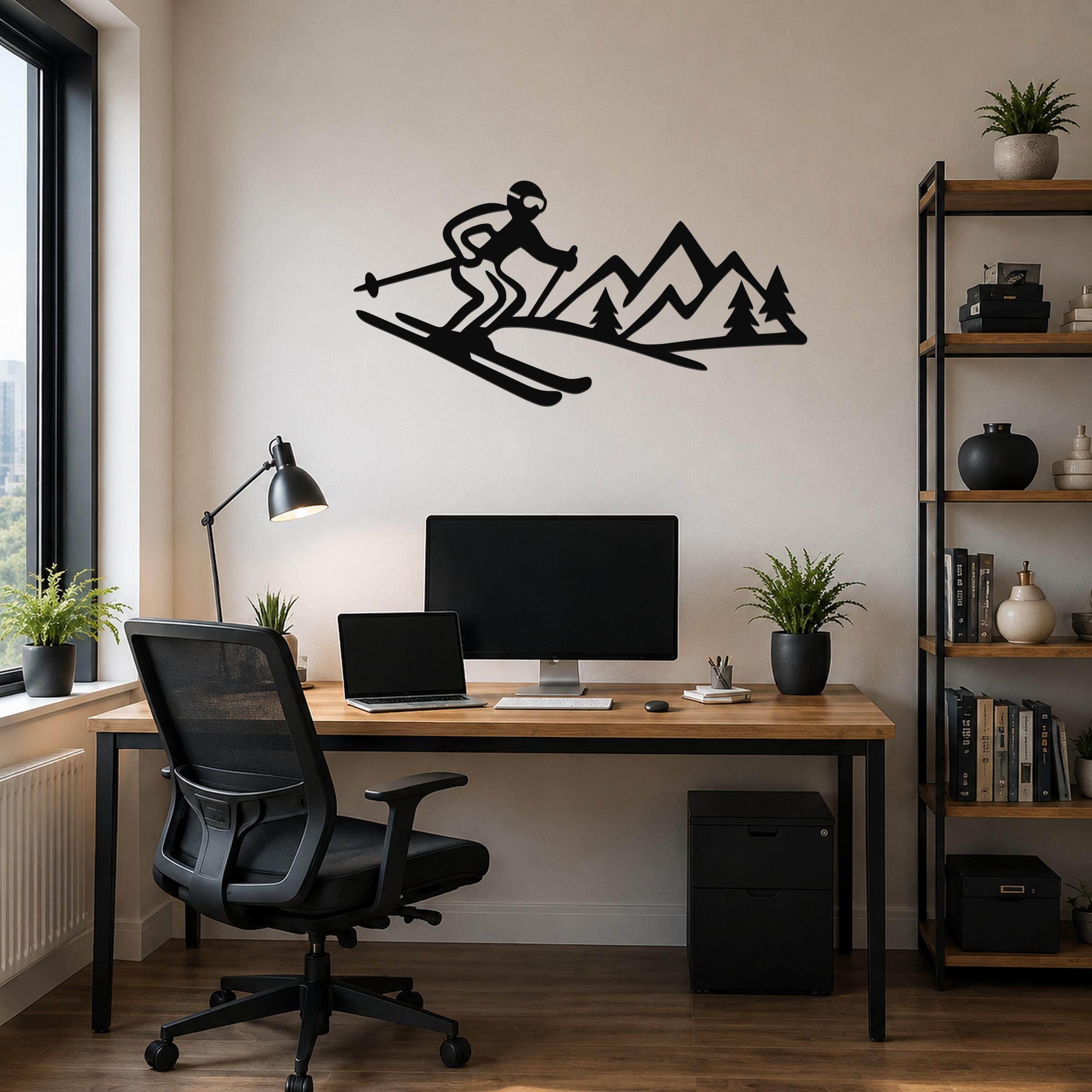 Black metal wall art cutout of a skier and mountain range, mounted above a wooden desk in a home office.