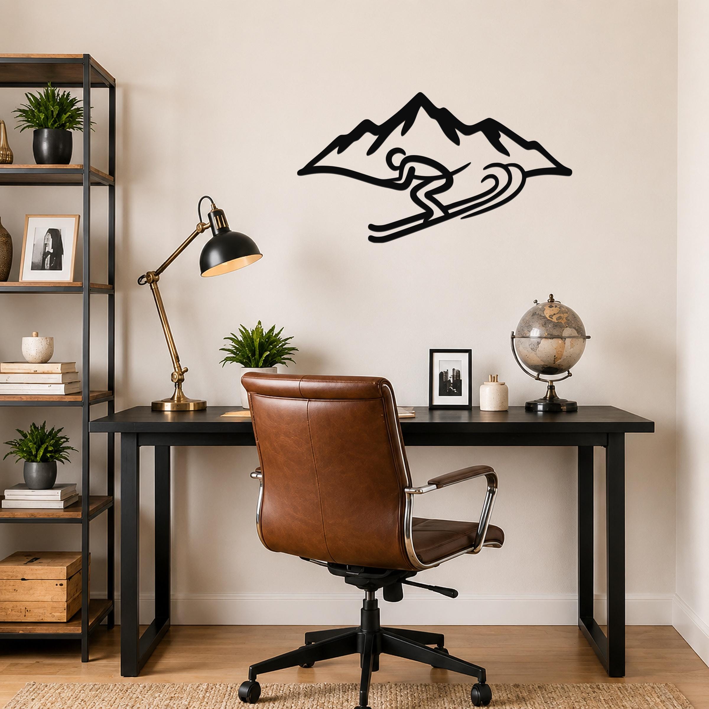 Black metal wall art featuring a skier silhouette in motion above a mountain, mounted on a wall above a black desk in a home office.