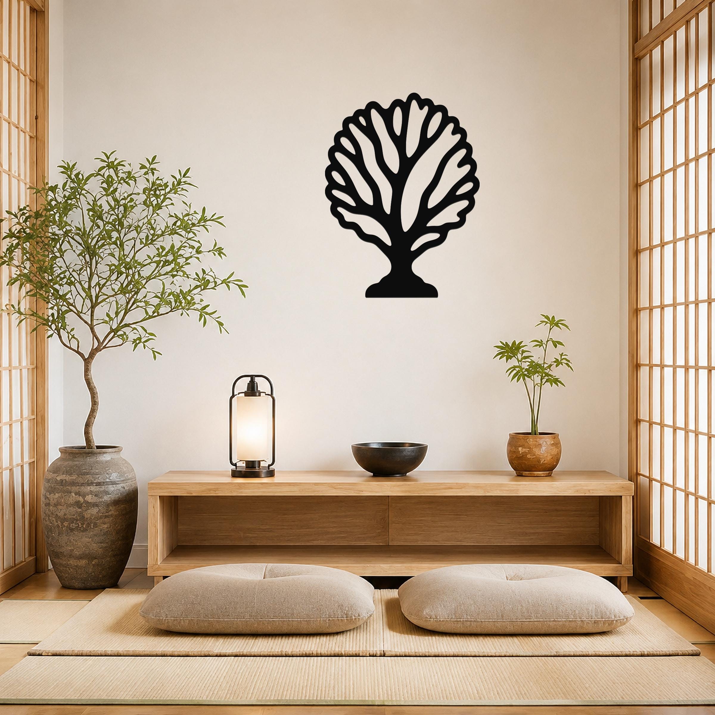 Black metal fan coral wall art with intricate branch cutouts, mounted on a light-colored wall above a wooden console in a minimalist room.