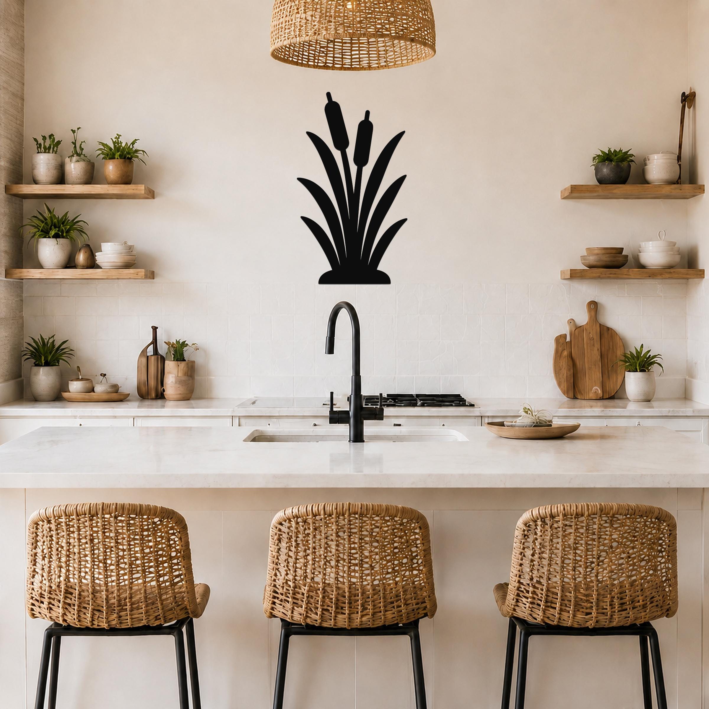 Black metal cattail wall art silhouette mounted on a kitchen wall above a counter, with wicker bar stools and open shelves visible below.