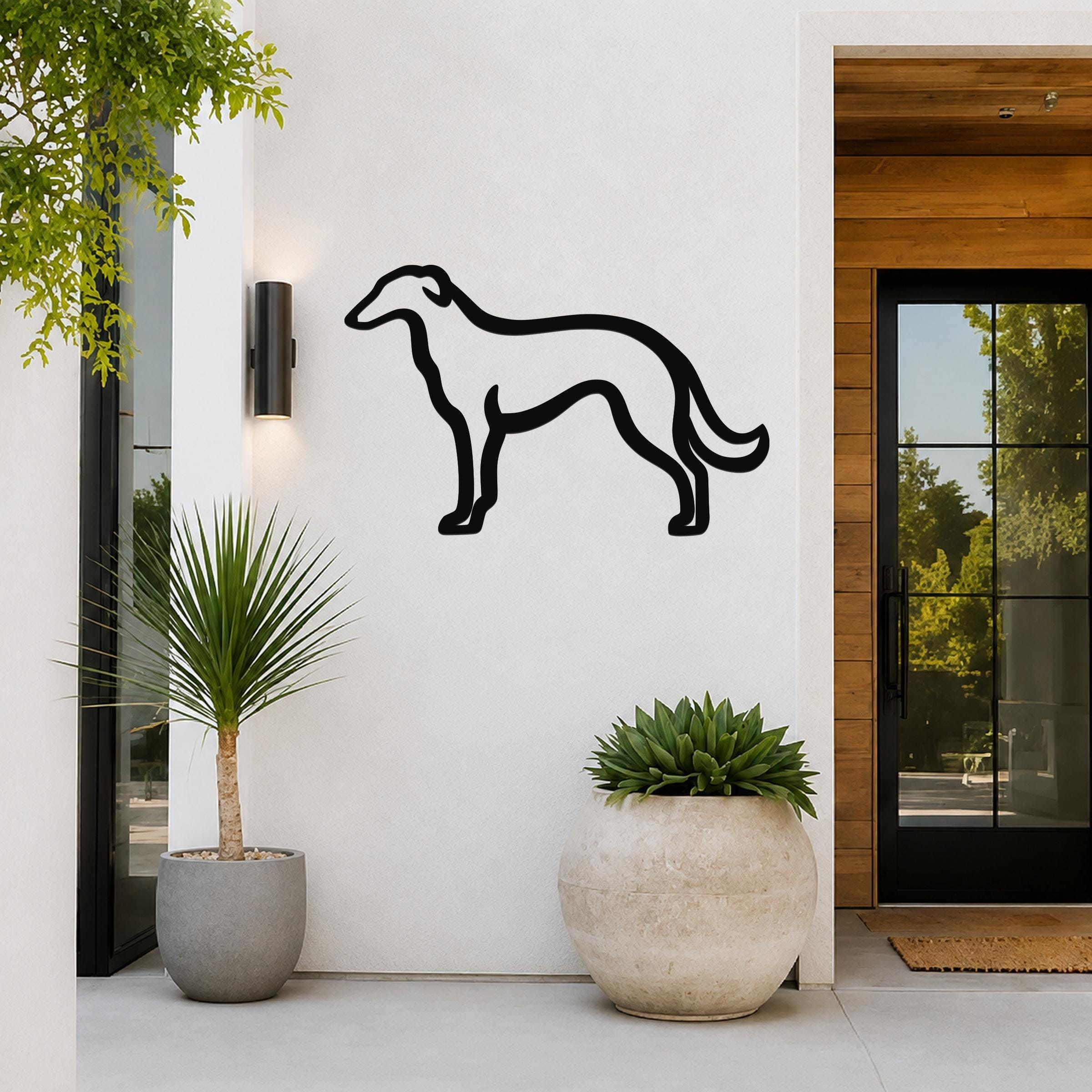 Black metal Borzoi dog silhouette wall art mounted on a white exterior wall beside a glass door and potted plants.