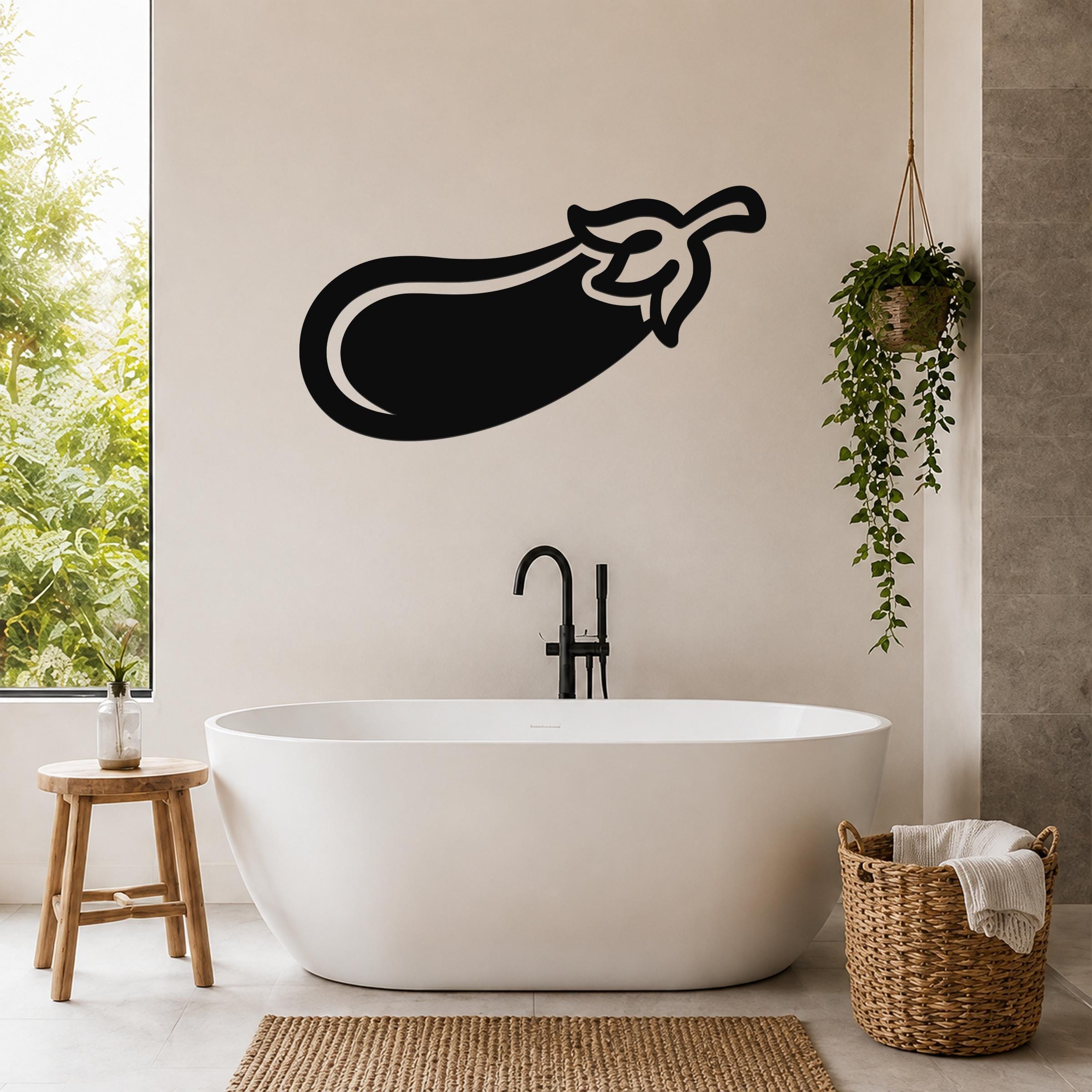 Black metal eggplant wall art silhouette mounted on a bathroom wall above a freestanding tub.